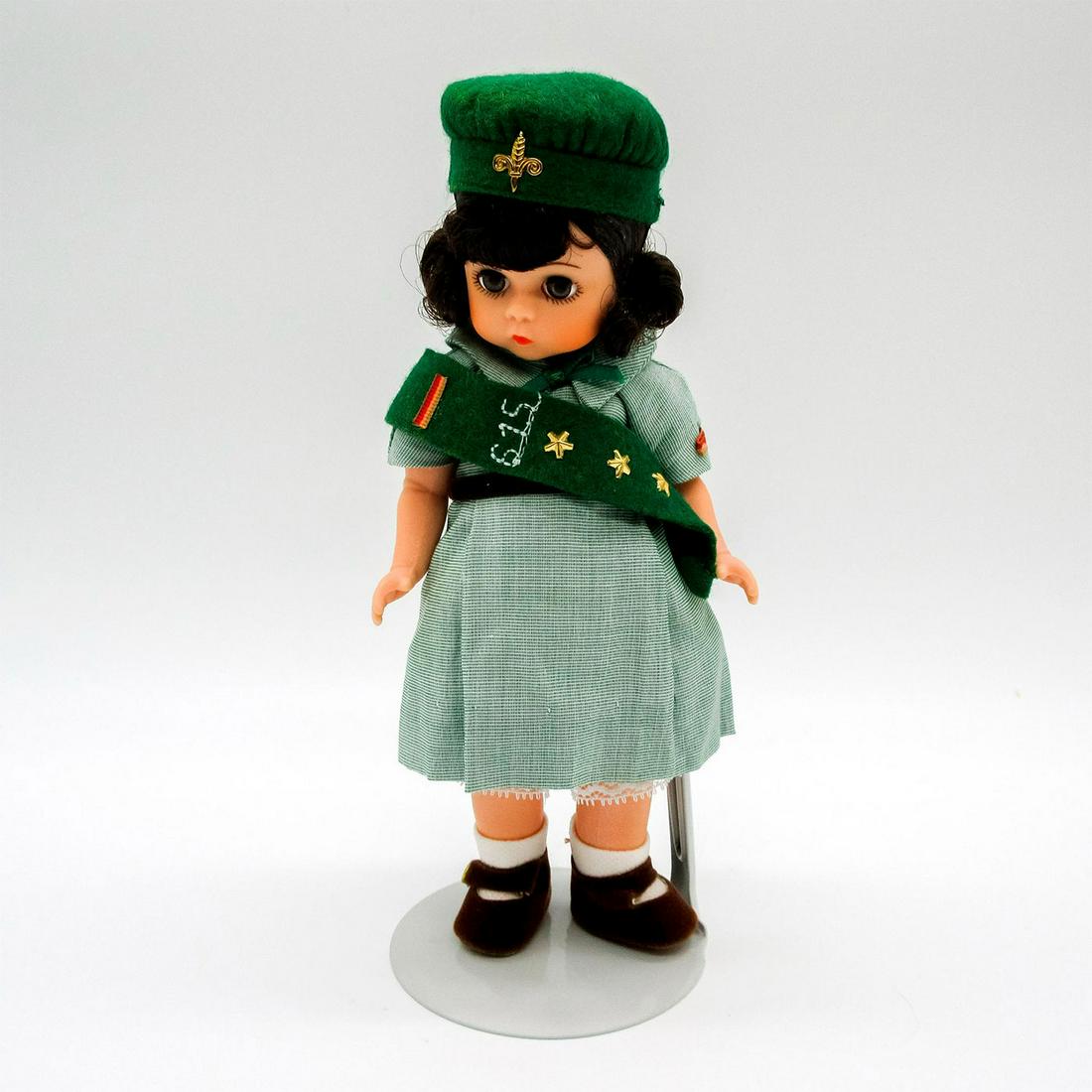 Vintage Madame Alexander Doll, Scouting: Dressed in pale green dress, green hat and sash, and brown shoes. Madame Alexander backstamp on back. Comes with stand. This item has no reserve. Dimensions: 7.75" H Manufacturer: Madame Alexander Cou