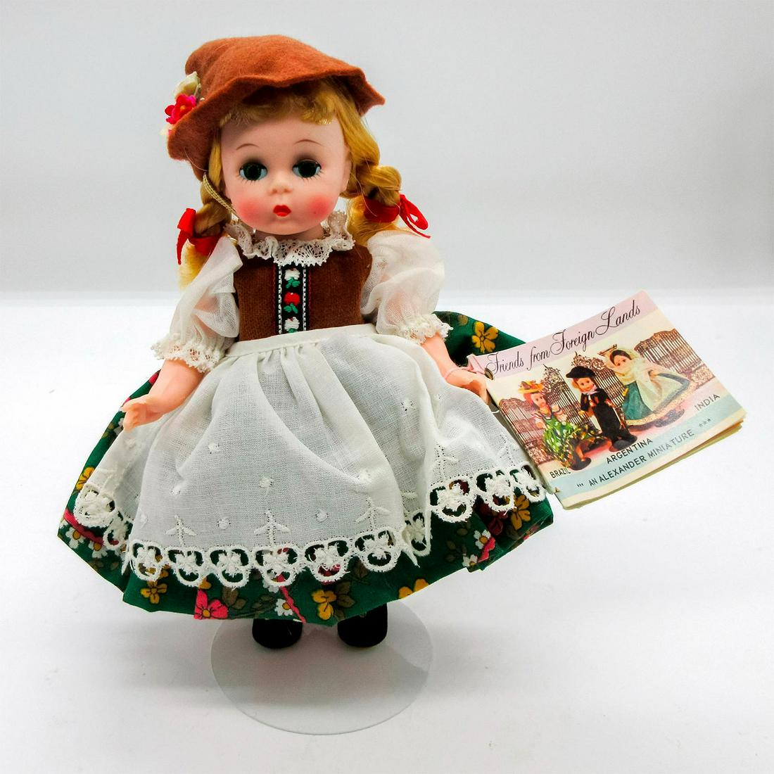 Vintage Madame Alexander Doll, Tirolean Girl: Dressed in multicolored dress, brown hat, and black shoes. Madame Alexander backstamp on back. Comes with stand. This item has no reserve. Dimensions: 7.75" H Manufacturer: Madame Alexander Country of