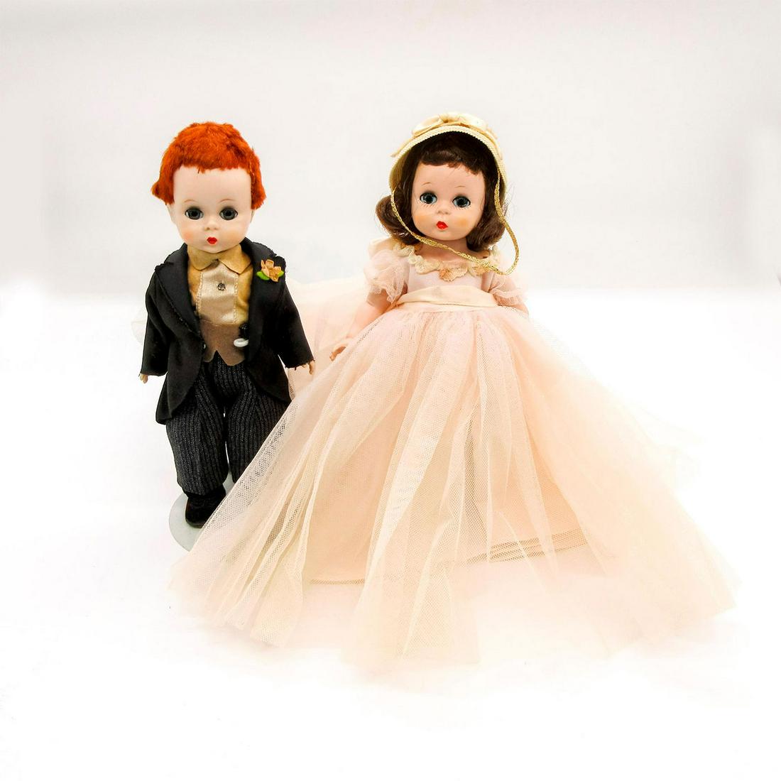 2pc Madame Alexander Dolls, Bridal Party: Elegantly dressed, with girl in light pink dress. Boy in black and grey suit, with tan shirt. Madame Alexander backstamps on back. Come with stands. This item has no reserve. Dimensions: 7.5" H Manufa