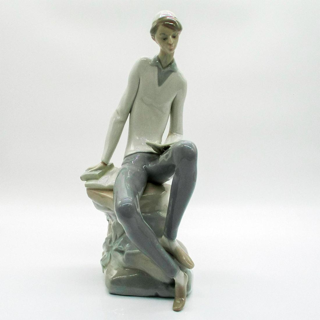 Hebrew Student 1004684 - Lladro Porcelain Figurine: Glossy finish porcelain that is part of Lladro's historical collection. Lladro backstamp. A young man sitting down reading a book. Artist: Juana Huerta Issued: 1970-1985 Dimensions: 3.75" L x 6.5" W x
