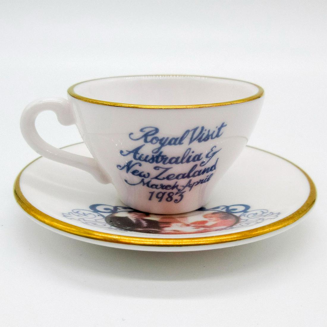 Caverswall Miniature Royal Visit Tea Cup and Saucer: Gilded gold, white bone china; honoring Prince Charles's and Princess Diana's 1983 visit to Australia and New Zealand. Caverswall backstamp. Issued: 20th c. Dimensions: 0.75" H x 2" dia. Manufacturer:
