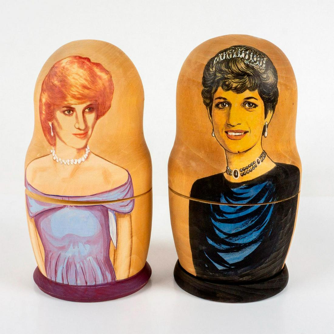 Pair of Wooden Princess Diana Nesting Dolls: Painted portraits of Princess Diana and the royal family on stacking dolls. 'Made in Russia' sticker on one base. 'Punk Ribbons Crusade, 2000 A.K. Sample' handwritten in black on the other base. Issue