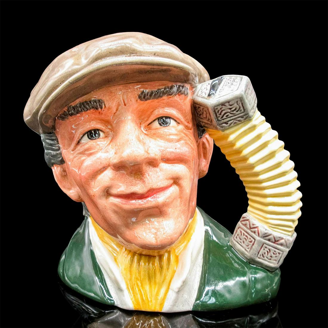 Busker D6775 - Large - Royal Doulton Character Jug: Glazed, hand painted ceramic. The minstrel is in a green coat, yellow scarf, and grey cap. The handle is an open concertina. Royal Doulton backstamp, and artist signature. Artist: Stanley J. Taylor Is