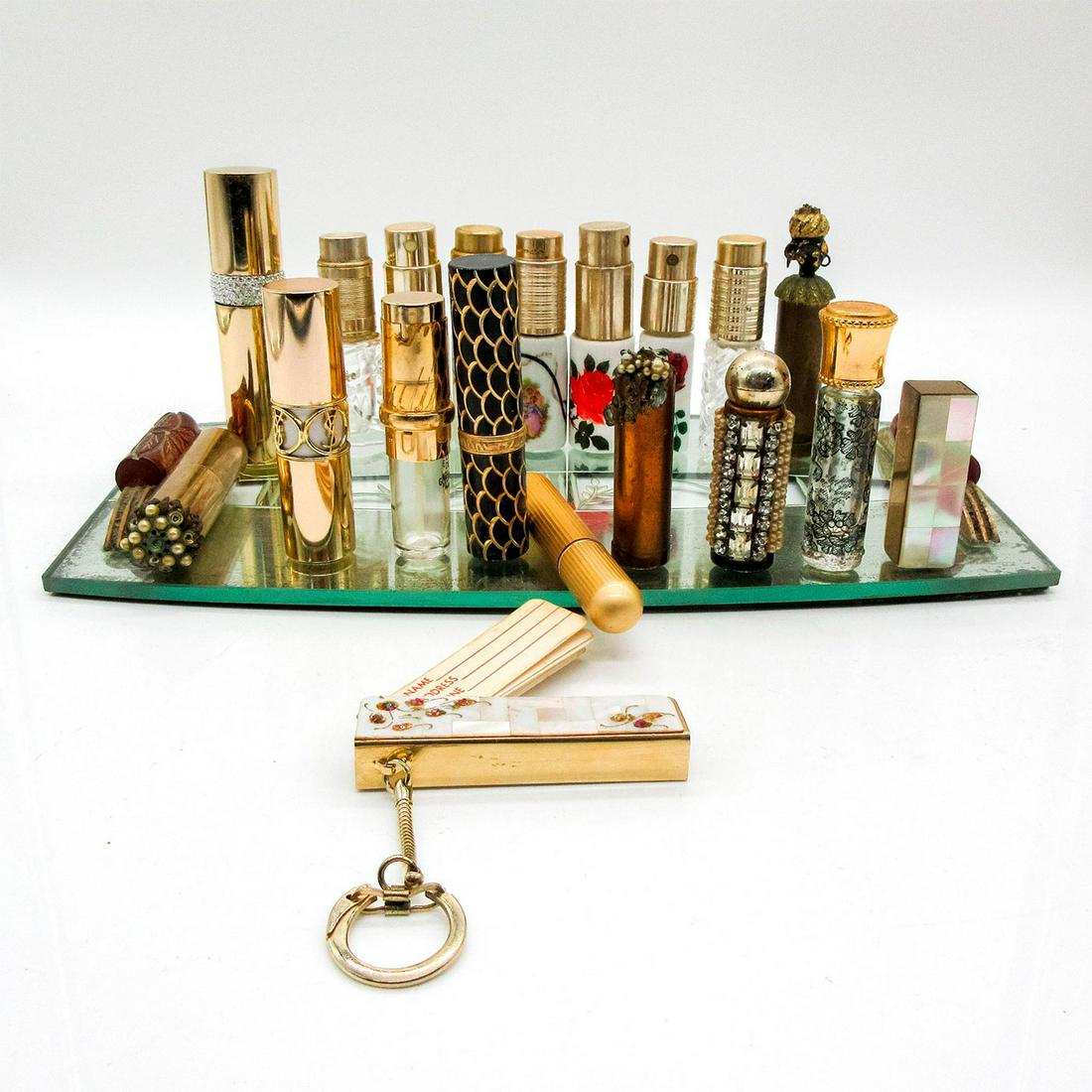 20pc Vintage Ladies Perfume Bottles & Mirrored Beauty Tray: Includes perfume bottles similar in size to a tube of lipstick. Includes one actual lipstick. Includes one keychain. Several bottles say Made In France, Imported From France, or Made in Austria. Perfu