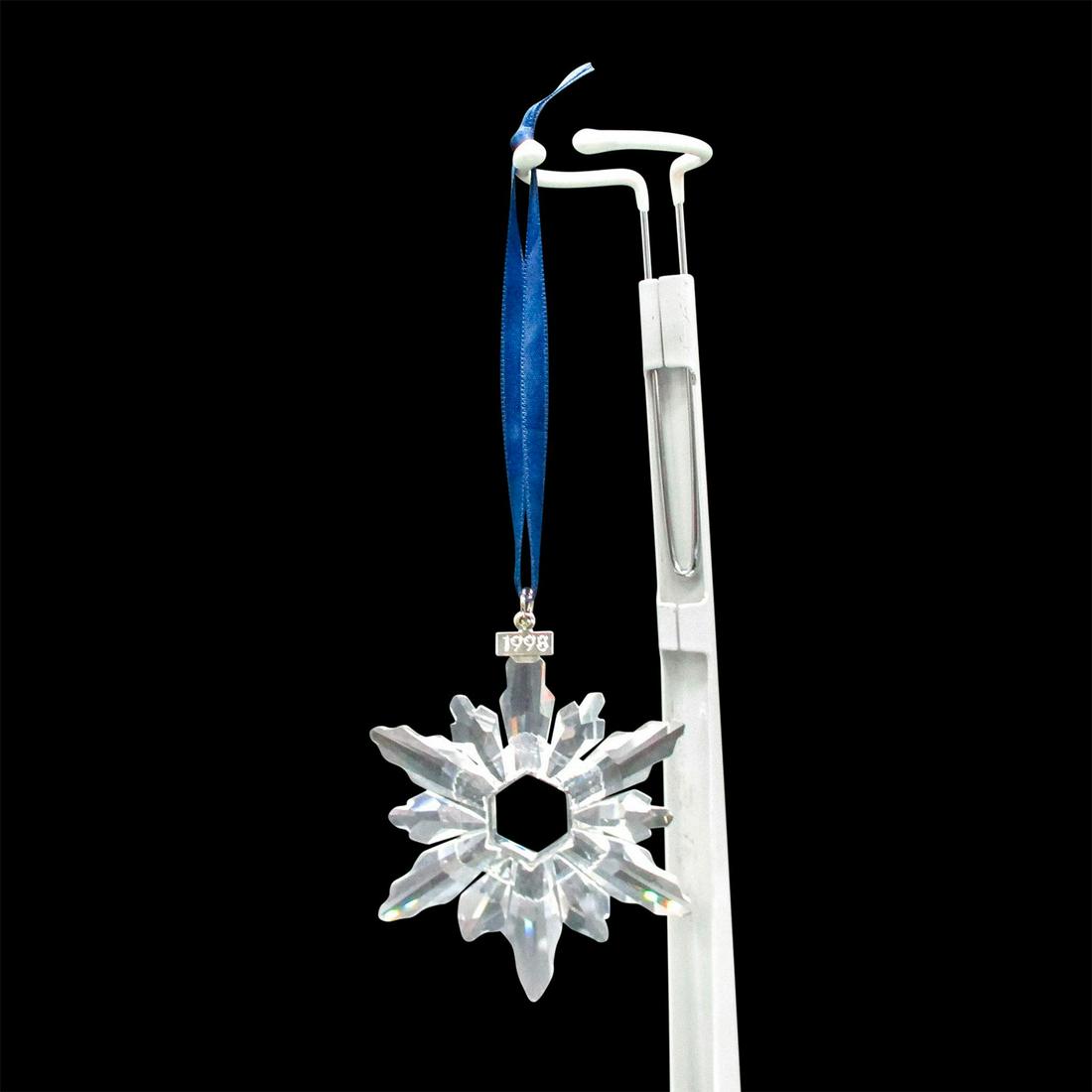 Swarovski Crystal 1998 Holiday Ornament: Lead crystal limited edition annual Christmas snowflake with 1998 tag on ornament and satin ribbon. Swarovski etched backstamp. Includes original box: 6"L x 4"W x 1"H. Issued: 1998 Dimensions: 1.5" L