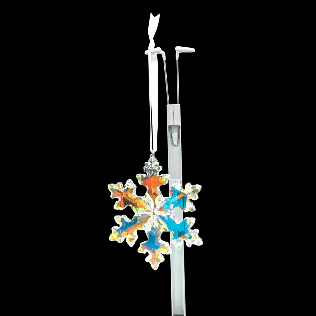 Swarovski Crystal 25th Anniversary Ornament: Lead crystal limited edition annual Christmas snowflake with 25th tag on ornament and satin ribbon. Changes color with movement. Swarovski etched backstamp. Includes original box: 9.5"L x 5.75"W x 1.5