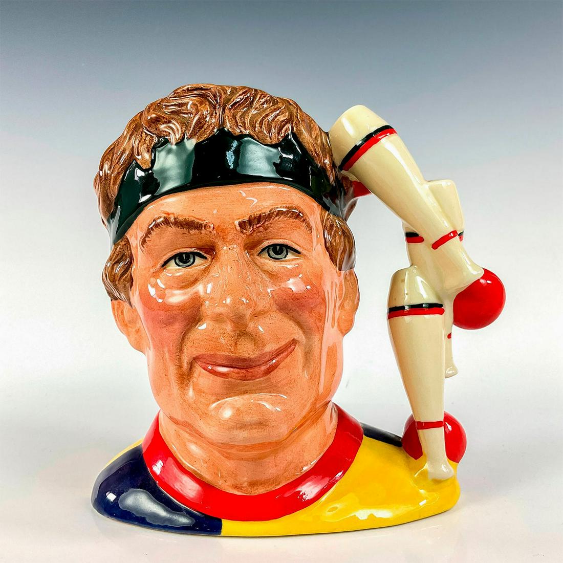 Juggler D6835 - Large - Royal Doulton Character Jug: Brown hair, yellow; blue and red tunic; dark green head band. Royal Doulton backstamp. Royal Doulton backstamp. Artist: Stanley J. Taylor Issued: 1988 - 1991 Dimensions: 6.5"H Manufacturer: Royal Doul