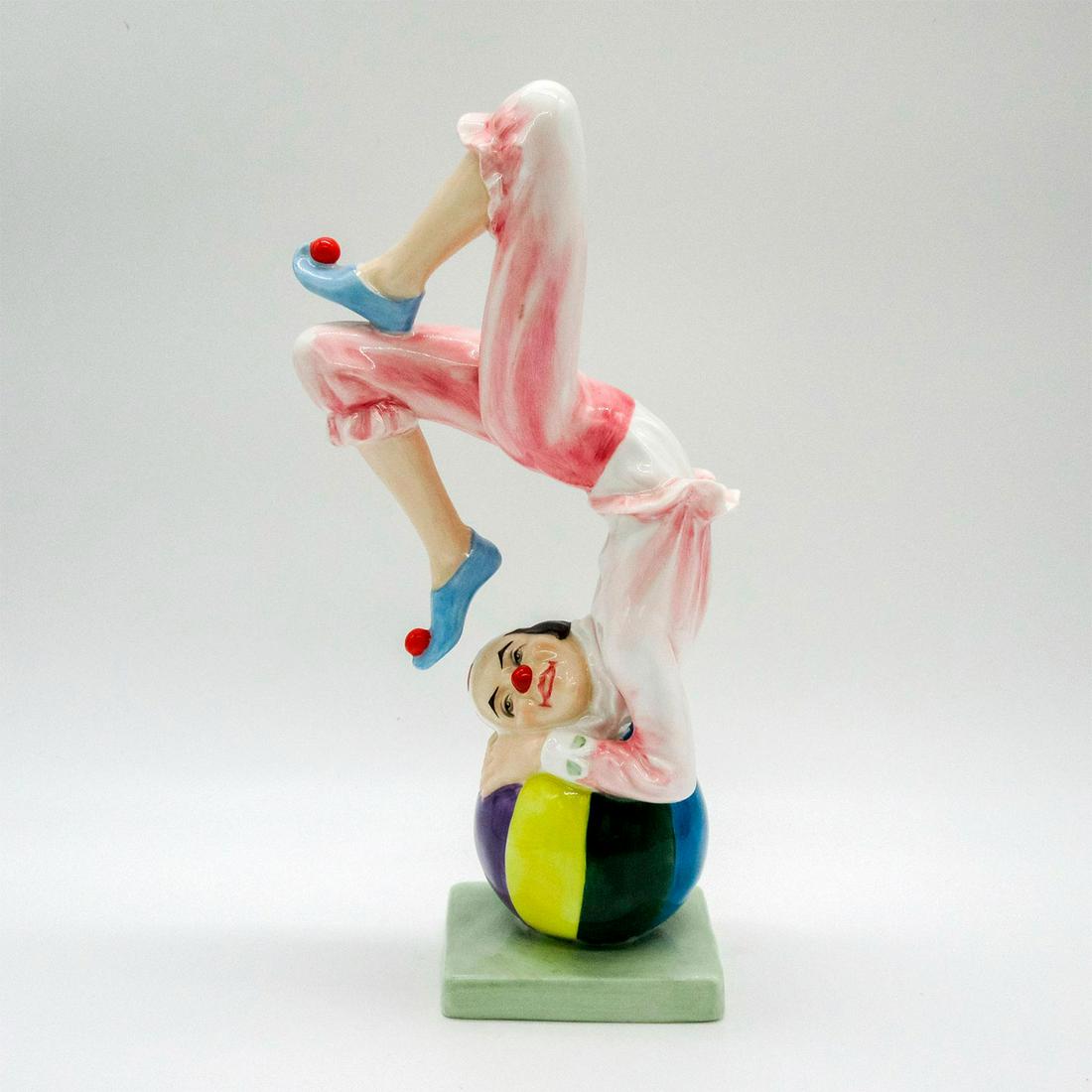 Tumbling HN3289 - Royal Doulton Figure: A jubilant clown balancing on a circus ball. Pink and white coloration. Royal Doulton backstamp. Artist: Douglas V. Tootle Issued: 1991 Dimensions: 2.5"L x 4.25"W x 9"H Edition Number: 139 of 2500 Man