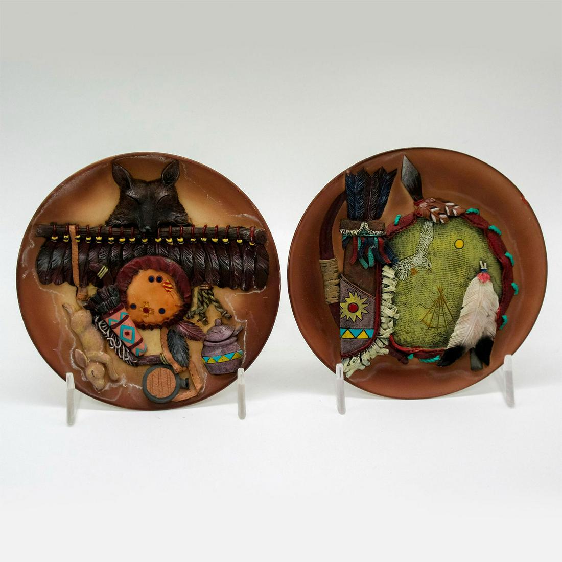 Pair of Signed Native American Acrylic Cabinet Plates: Small tawny-brown plates adorn detailed carved reliefs. Artist's signature on the bases. Dimensions: 5" Diameter