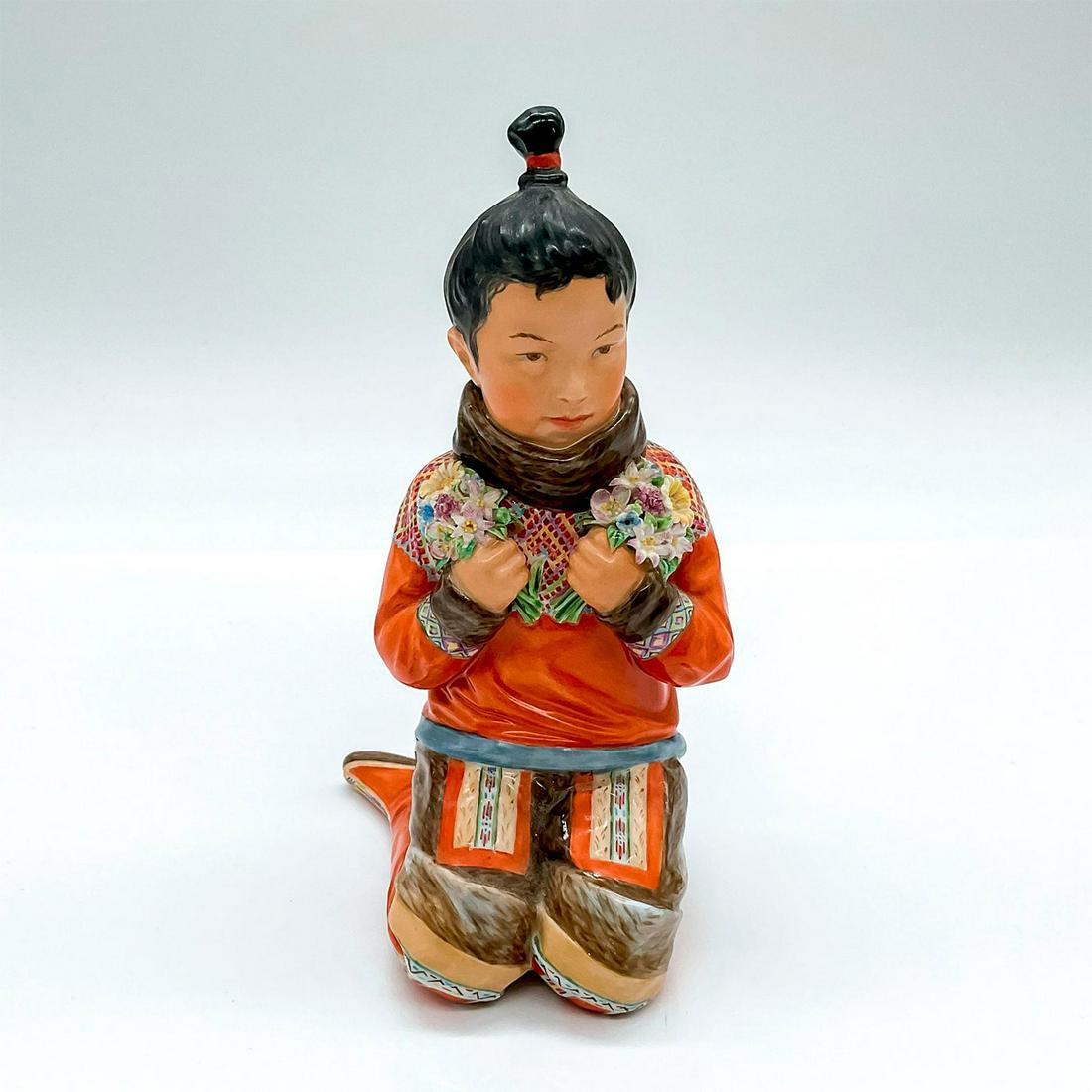 Royal Copenhagen Porcelain Figurine, Greenland Girl: Figure of a young Greenlander in orange clutching wildflowers. 12415; Royal Copenhagen backstamp. Artist: Carl Martin-Hansen Issued: c. 1943 Dimensions: 3.5"L x 3"W x 5.75"H Manufacturer: Royal Copenh