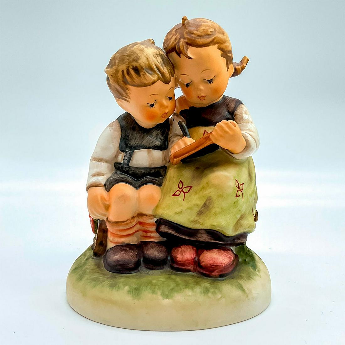 Goebel Hummel Figurine, The Smart Little Sister: Porcelain hand painted in matte finish. Goebel backstamp. Impressed M. I. Hummel to round base. Artist: M. I. Hummel Issued: 1956 Dimensions: 2.75"W x 4.5"H x 3.25"Dia. Manufacturer: Goebel Hummel Cou