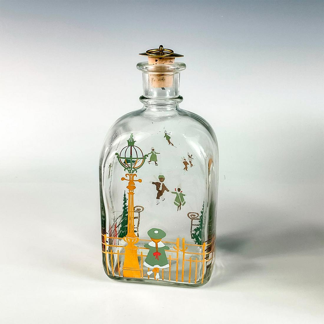 Holmegaard of Copenhagen Christmas Bottle 1988: Decorated glass bottle, festive winter scene of people ice skating. Green, red and gold. The other side features a girl leaning while watching the skaters. Holmegaard affixed label. Includes original