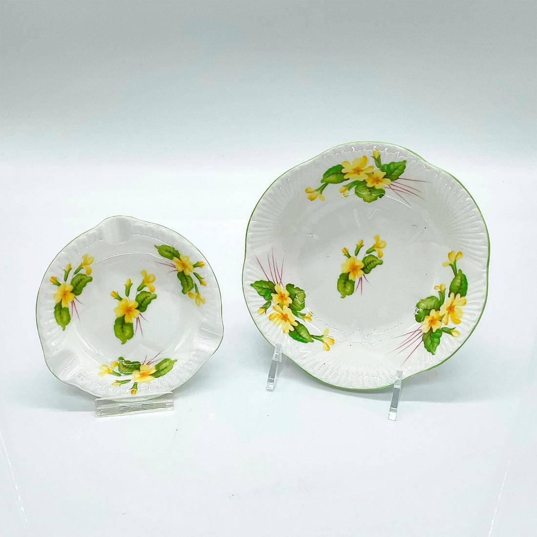 2pc Vintage Shelley Primrose, Small Bowl and Ashtray: Dainty shaped bone china with yellow flower pattern and green scalloped rim. Shelley England backstamp on base. This item has no reserve. Bowl measures: 5.25 W x 1.75 H x 3 D. Ashtray measures: 3.75 W
