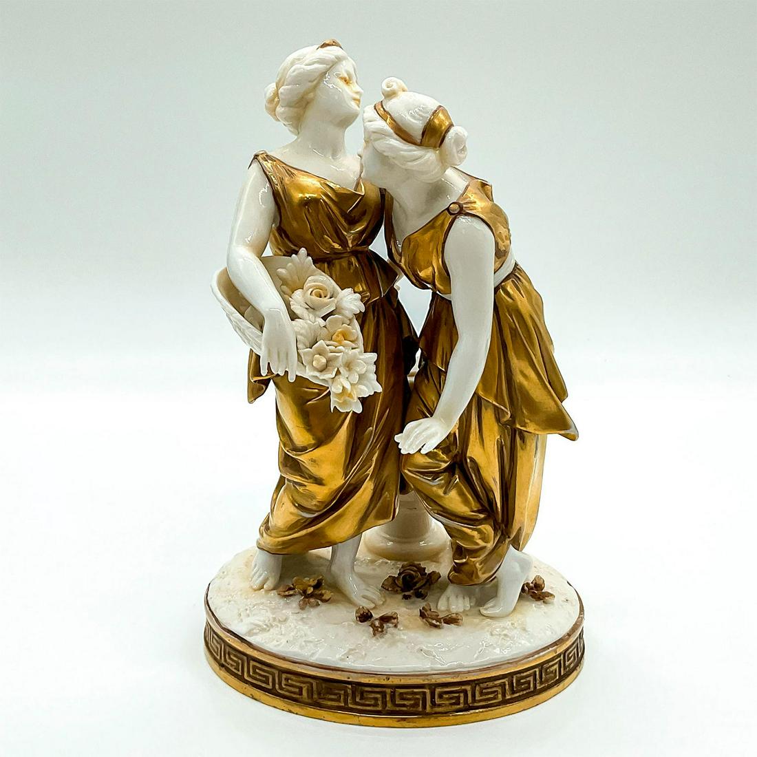 Capodimonte Style Golden Greek Figurine: Two Greek maidens in gilded peplos; standing on a oval base decorated with a Greek key border. Blue crown over N backstamp. Dimensions: 4.25"L x 4.75"W x 7.25"H