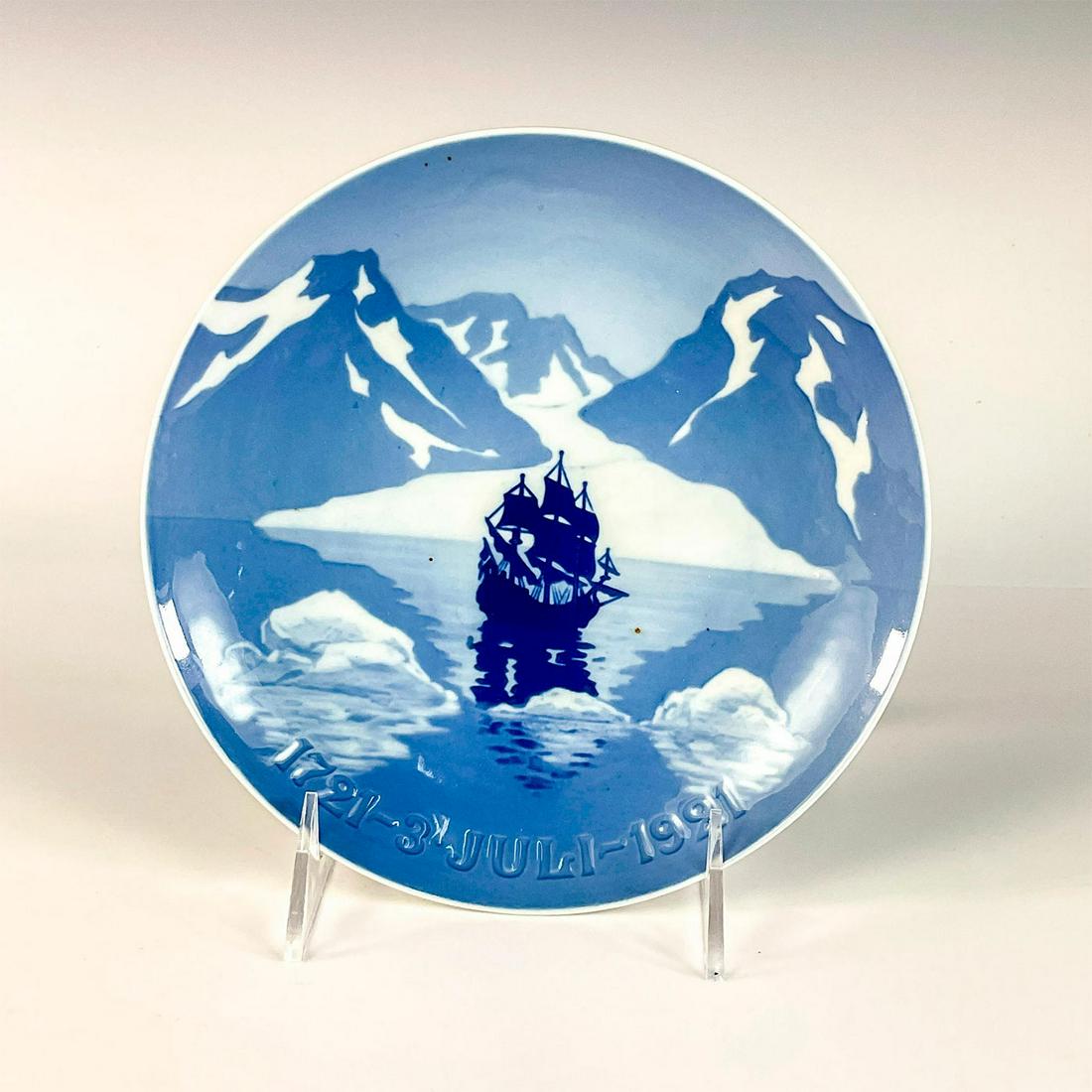 1921 Bing & Grondahl Jubilee Plate: Glossy finish. In blue and white coloration. Depicts the ship Haabet (Hope) arriving in Greenland on July 3rd 1721. B&G backstamp. With back openings for hanging. Dimensions: 7"Dia. Manufacturer: Bing