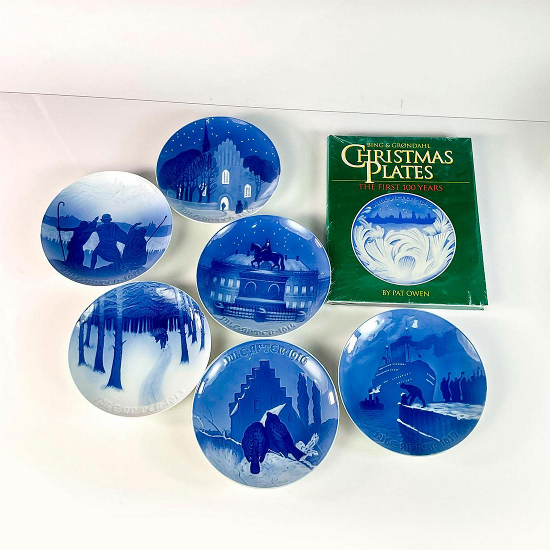 7pc Bing and Grondahl Christmas Plates and Book Set: Includes six plates for the years: 1911-1914, 1916, and 1917. In blue and white coloration. Bing and Grondahl backstamp. Book is: 'Bing & Grondahl Christmas Plates, The First 100 Years', by Pat Owen,