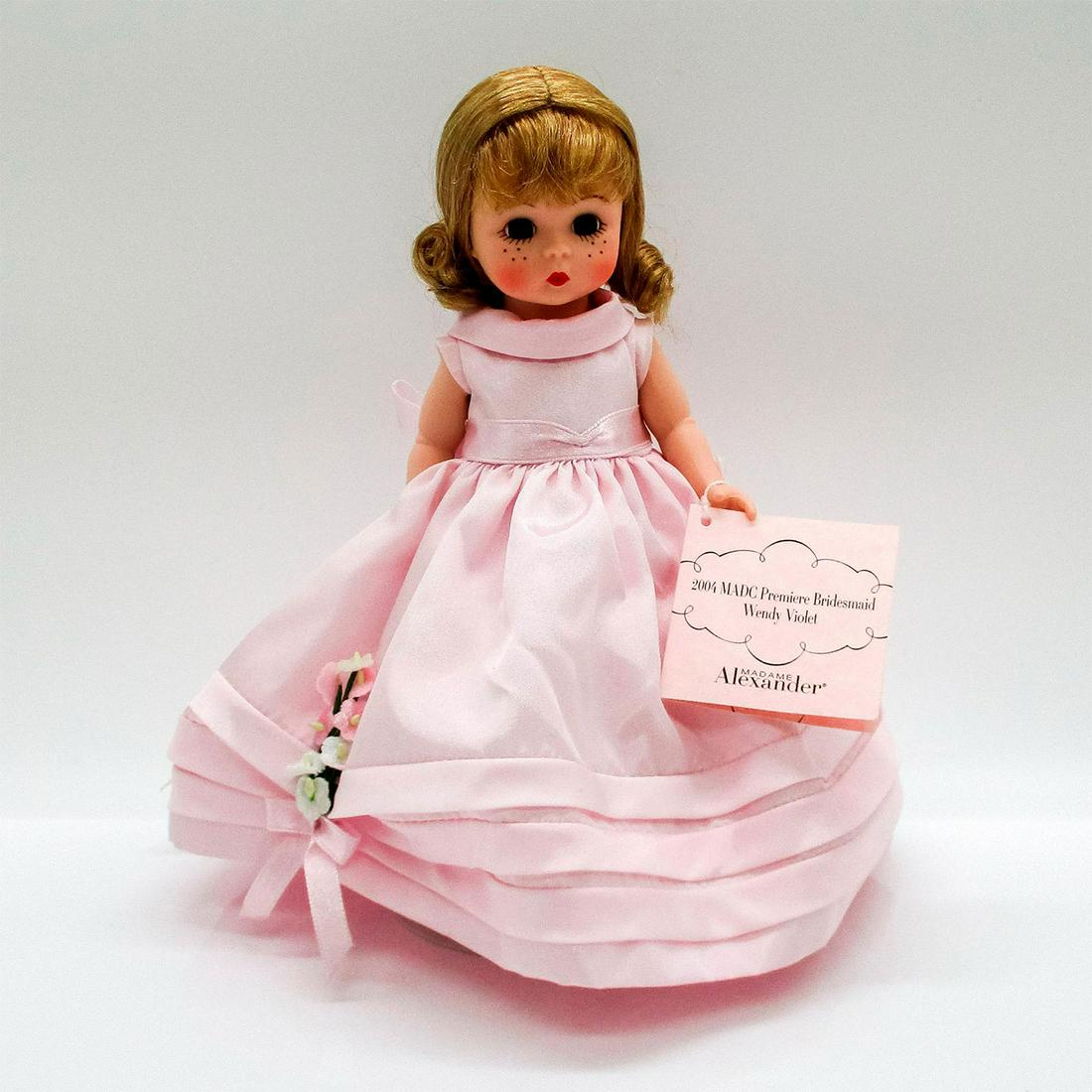 Madame Alexander Doll, Bridesmaid Wendy Violet: Vintage doll with stand that was made for MADC premiere. Jointed with moving eyes. Issued: 2004 Dimensions: 4.25" W x 8" H Manufacturer: Madame Alexander Country of Origin: United States