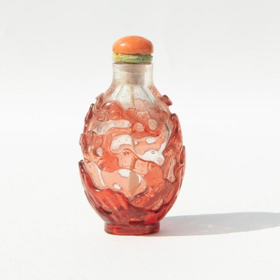 Antique Chinese Peking Glass Snuff Bottle with Stopper: Beautiful bicolored glass overlay carved with birds perched on a blossom tree; with coral stopper. Dimensions: 1.5"L x 1.25"W x 2.75"H Country of Origin: China