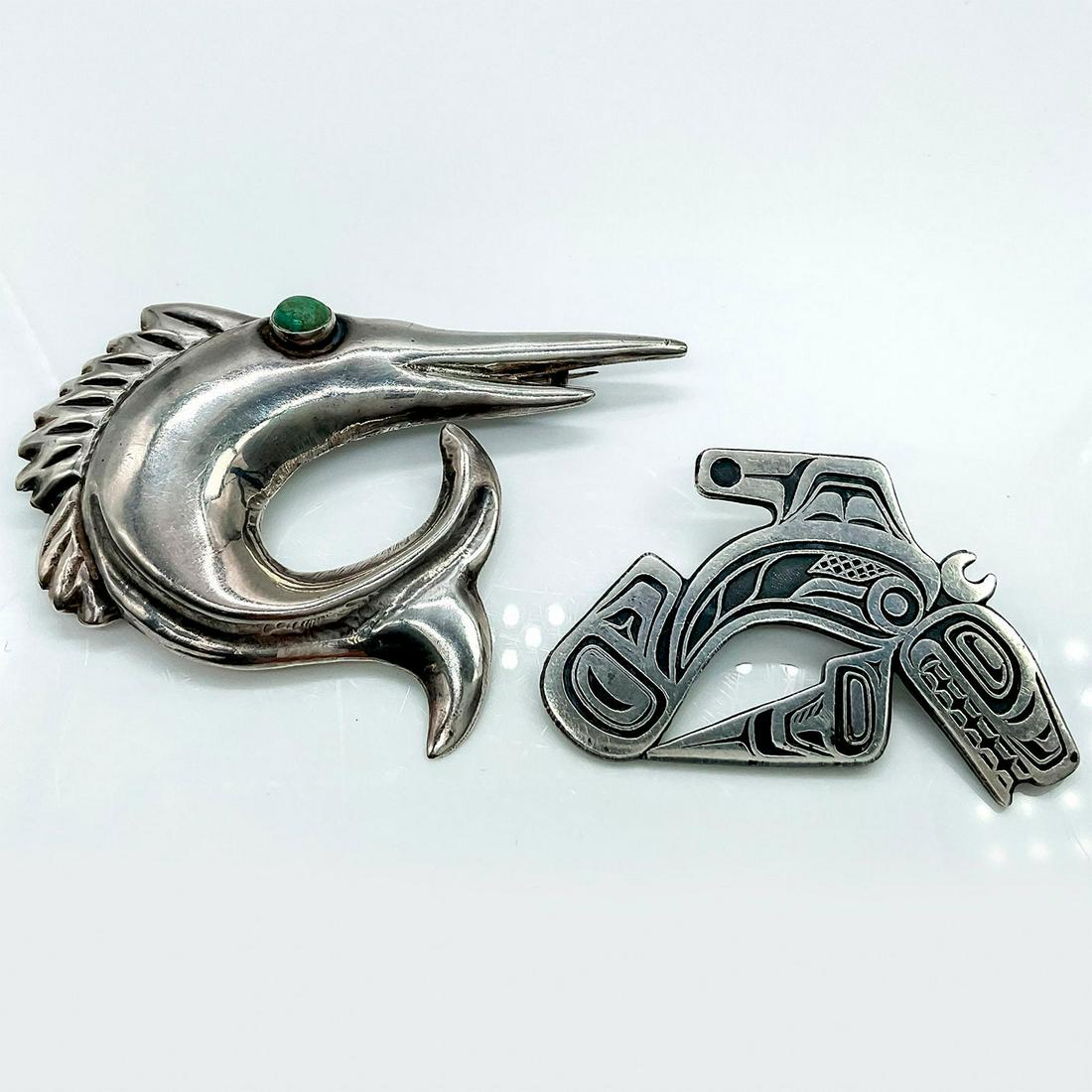 2pc Native American Orca and Fish Sterling Silver Brooches: Includes a west coast native orca pin with distinct big teeth and large dorsal fin with black overlay details and a marlin fish with gemstone eye. Hallmarked Sterling and PP to back of orca pin. Hallm