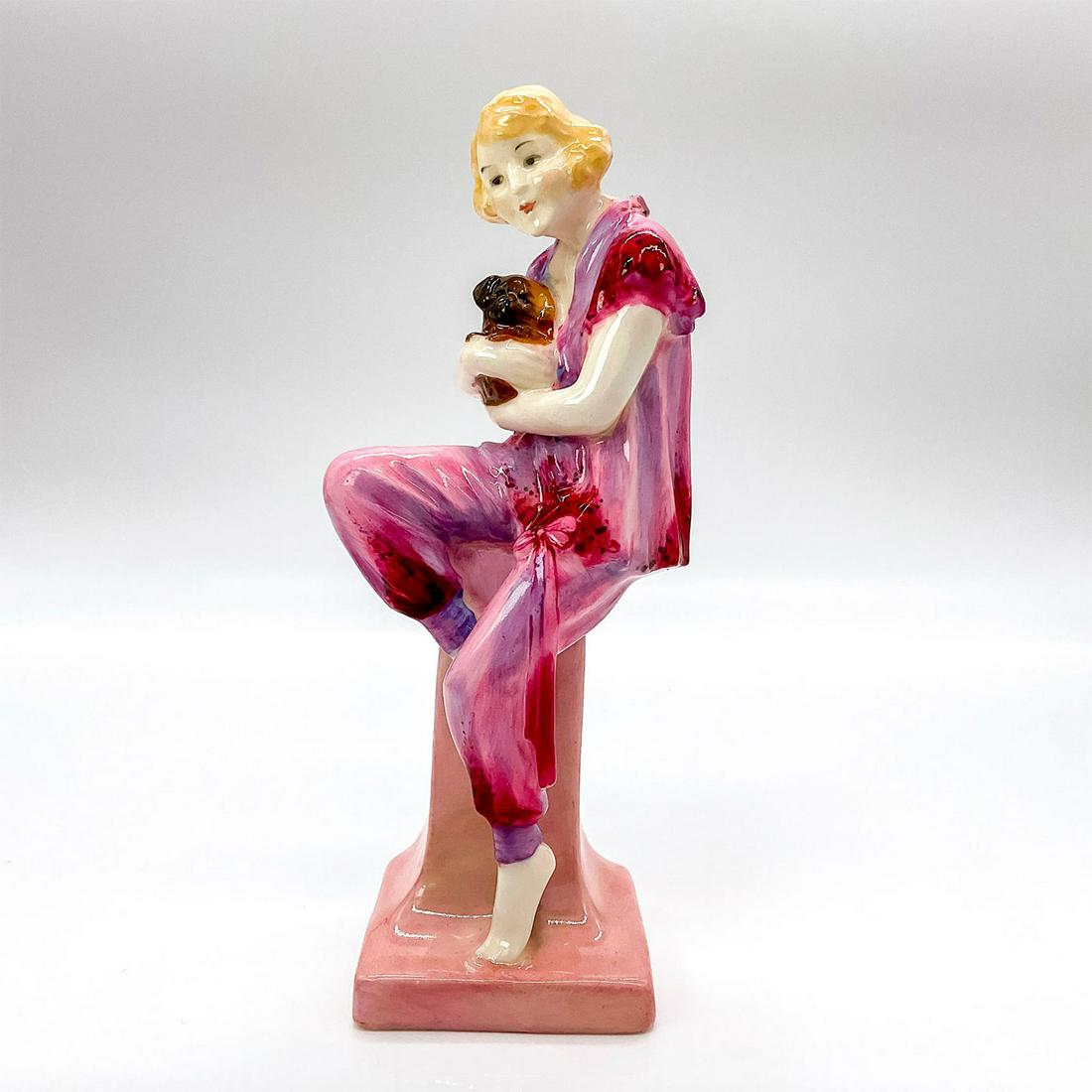 Lido Lady - HN1220 - Royal Doulton Figurine: Glossy finish porcelain depicting a young woman wearing a beach top and bottoms, seated with her dog. The name for this figure may have been taken from a Noel Coward song satirizing the modern fashion