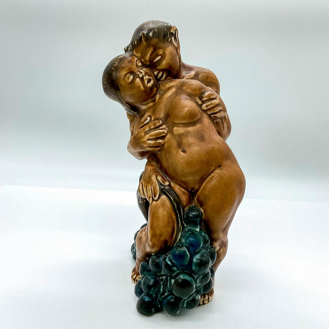 Bing and Grondahl Stoneware Figure, Saytr and Woman, Signed: Brown neoclassical figure that is part of the Grape Harvesting series. Modeled as a nude woman and saytr with a vine of grapes. Kai Nielsen engraved to bottom of figure. Bing and Grondahl impressed to