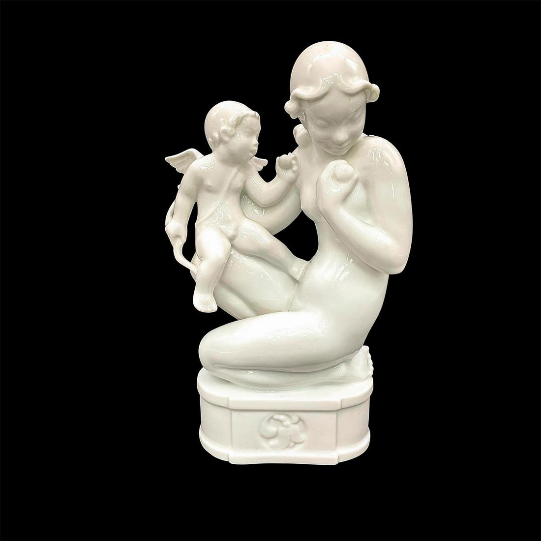 Dahl Jensen DJ Copenhagen Figurine, Venus and Cupid: Blanc de chine porcelain figure of Venus holding cupid on her knee. Venus holding an apple. Cupid holding his bow. 1034; Dahl Jensen DJ Copenhagen backstamp. Artist: Jens Peter Dahl Jensen Issued: c.