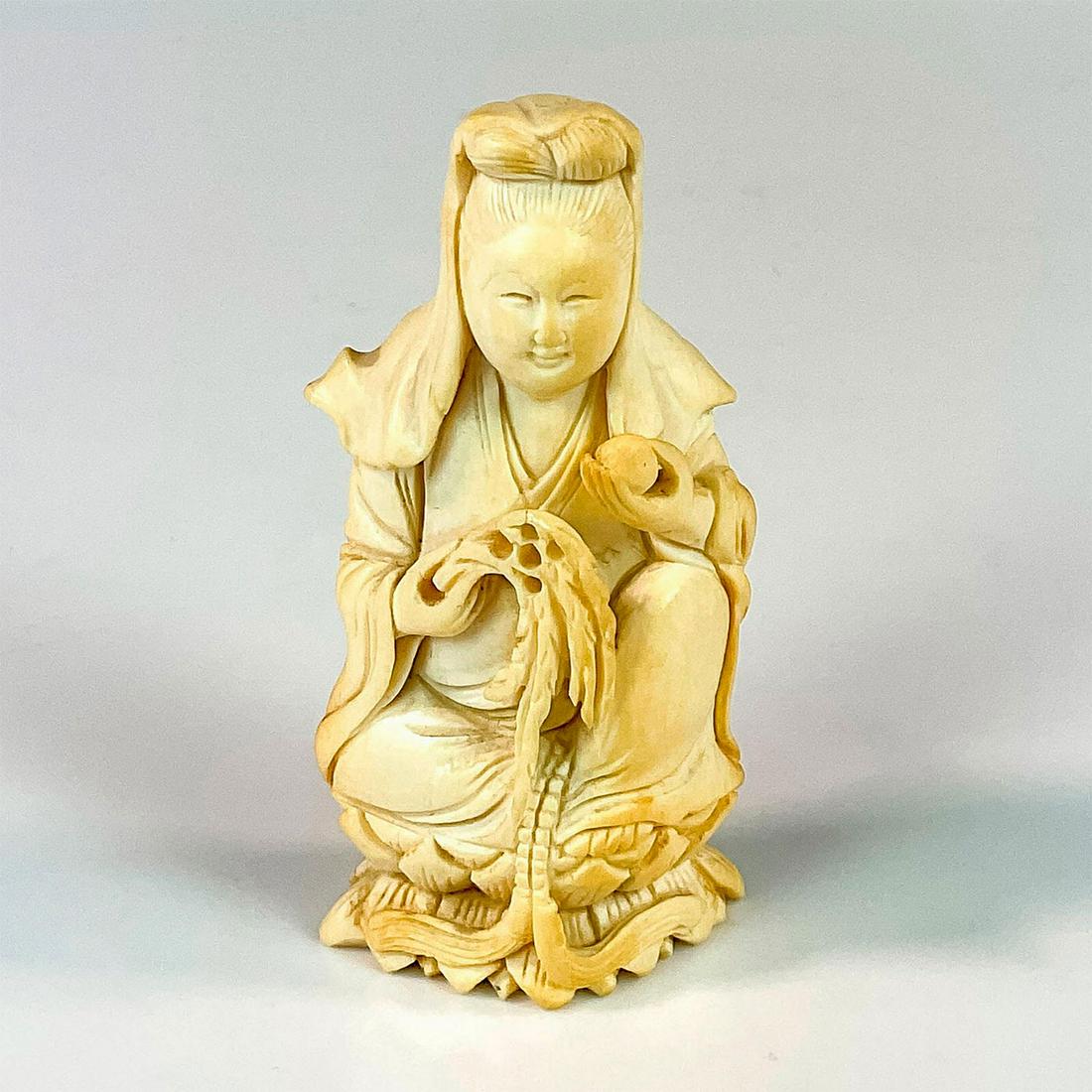 Chinese Small Carved Bone Guanyin Figurine: A beautiful hand carved figure of the Bodhisattva of compassion seated on a lotus. She is holding a willow branch and a peach. Dimensions: 1.75"L x 1"W x 3.25"H Country of Origin: China