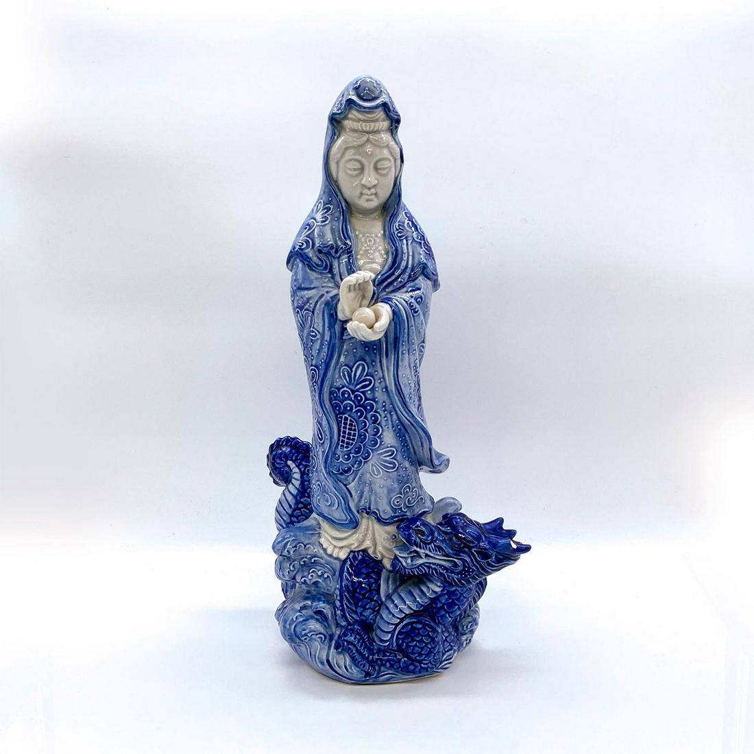 Chinese Ceramic Figurine, Guanyin: Depicts the Buddhist bodhisattva of compassion. In standing pose atop a dragon, dressed in blue robes and holding the Pearl of Light. Dimensions: 7.25"L x 4.5"W x 14.25"H