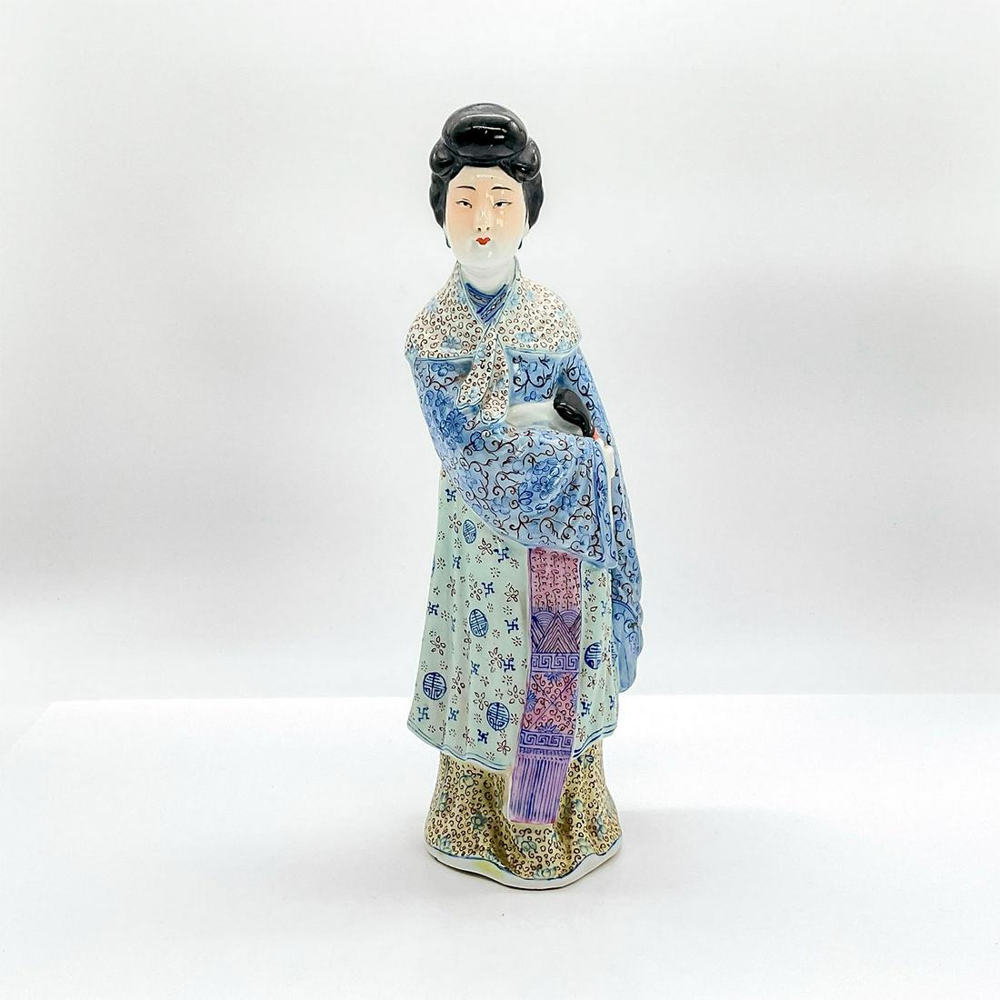 Chinese Figurine, Lady Concealing Sword: Vintage glazed ceramic figure of a standing lady in traditional blue, yellow and brown robe with Guang sleeves appears to be guarding her sword. Dimensions: 3.25"L x 3"W x 10"H Country of Origin: Chin