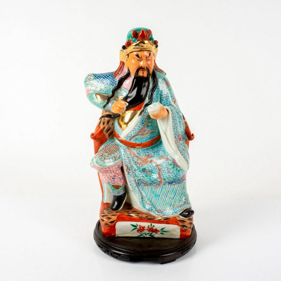 Chinese Porcelain Figure, Guan Yu: Intricately painted figure of Guan Yu, a Chinese military general serving under the warlord Liu Bei, playing a significant role in the ending. of the Han Dynasty, seated on a throne holding a scroll.