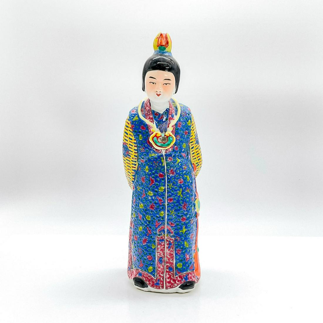 Vintage Chinese Figurine, Provincial Lady: Ceramic glazed figure of a lady standing in a blue, green, yellow and dark pink tunic dress with her hands behind her back. Dimensions: 3"L x 2.5"W x 10.25"H Country of Origin: China
