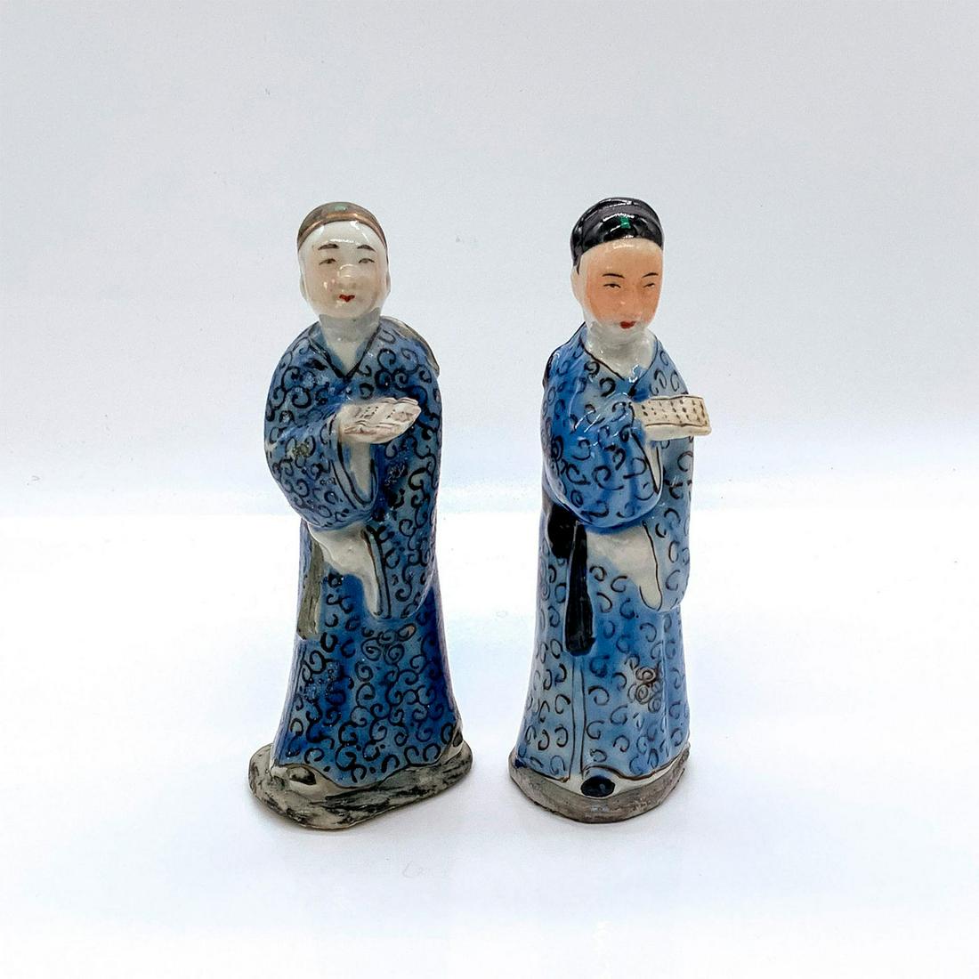 Pair of Chinese Porcelain Famille Rose Figurines, Scholars: Depicted wearing blue and black robes, in standing pose, holding an open book. Dimensions of largest: 2.5 in. L x 2 in. W x 6.25 in. H.