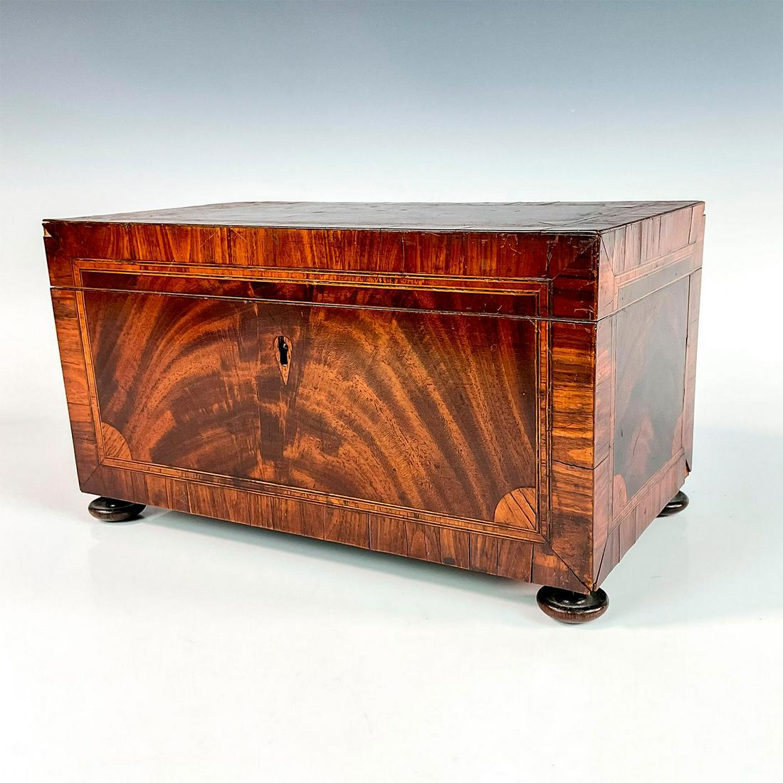 Antique Black Walnut and Cherry Inlay Footed Tea Caddy: Handsome tea caddy with cedar interior, lined in a deep wine velvet. Lacking interior tea boxes and bowl, dividers intact. Original key included. Issued: Early 1800's Dimensions: 12"L x 6.5"W x 6.5"H 
