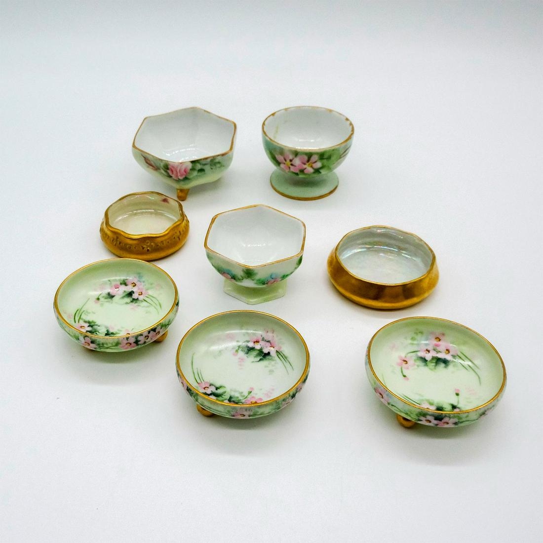 8pc Vintage European Gilded Salt Cellars: Assortment of beautifully painted salt cellars. 3 from O&EG Royal Austria, 2 from Germany, and 1 from Belleek. Manufacture marked on bases. O&EG Royal Austria: 0.75in x 2in. Record Germany: 1in x 2in.
