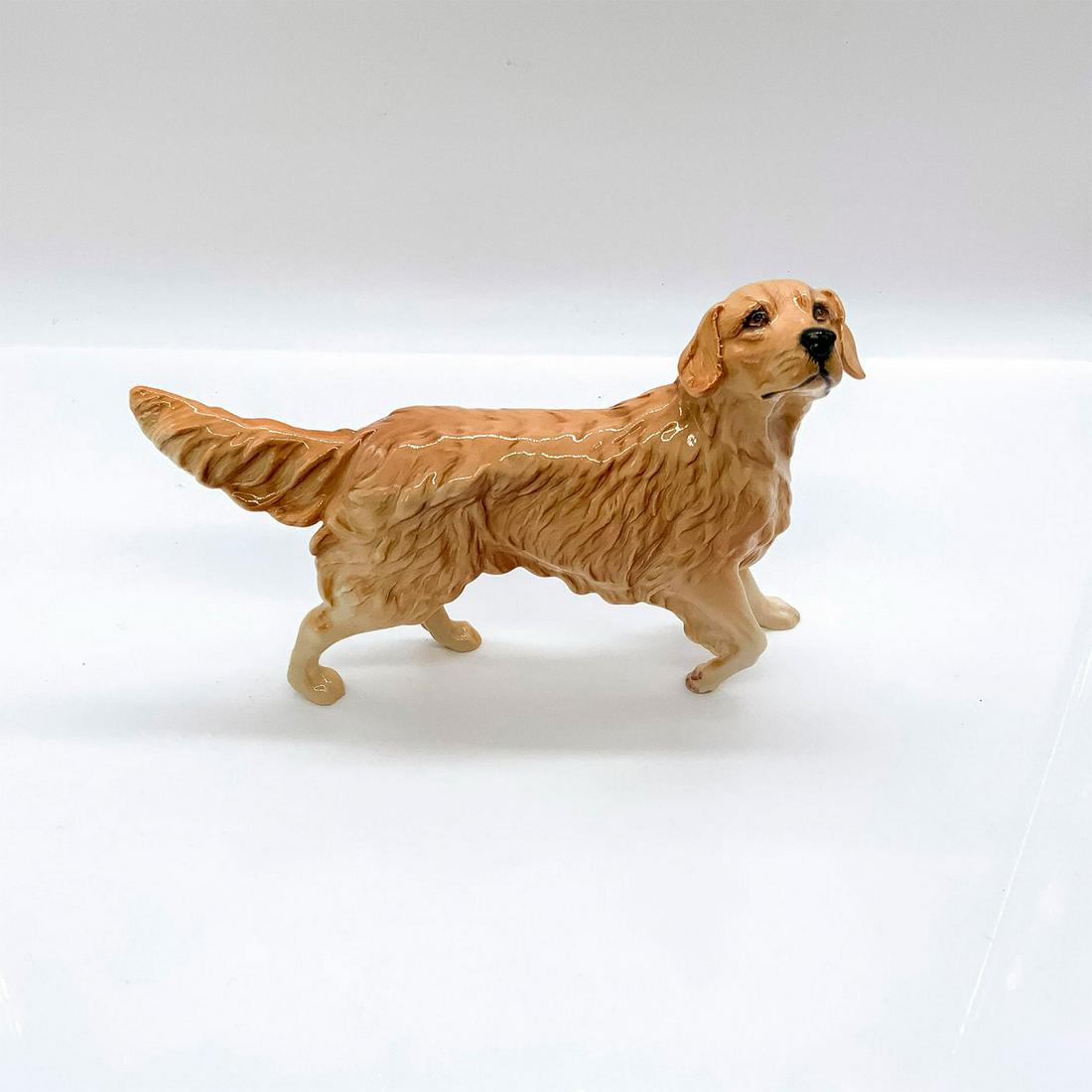 Royal Doulton Animal Figurine, Golden Retriever DA142: Glossy finish. In golden brown coloration. Royal Doulton backstamp. Artist: Amanda Hughes-Lubeck Issued: 1990-1999 Dimensions: 7"L x 2"W x 4.75"H Manufacturer: Royal Doulton Country of Origin: Eng