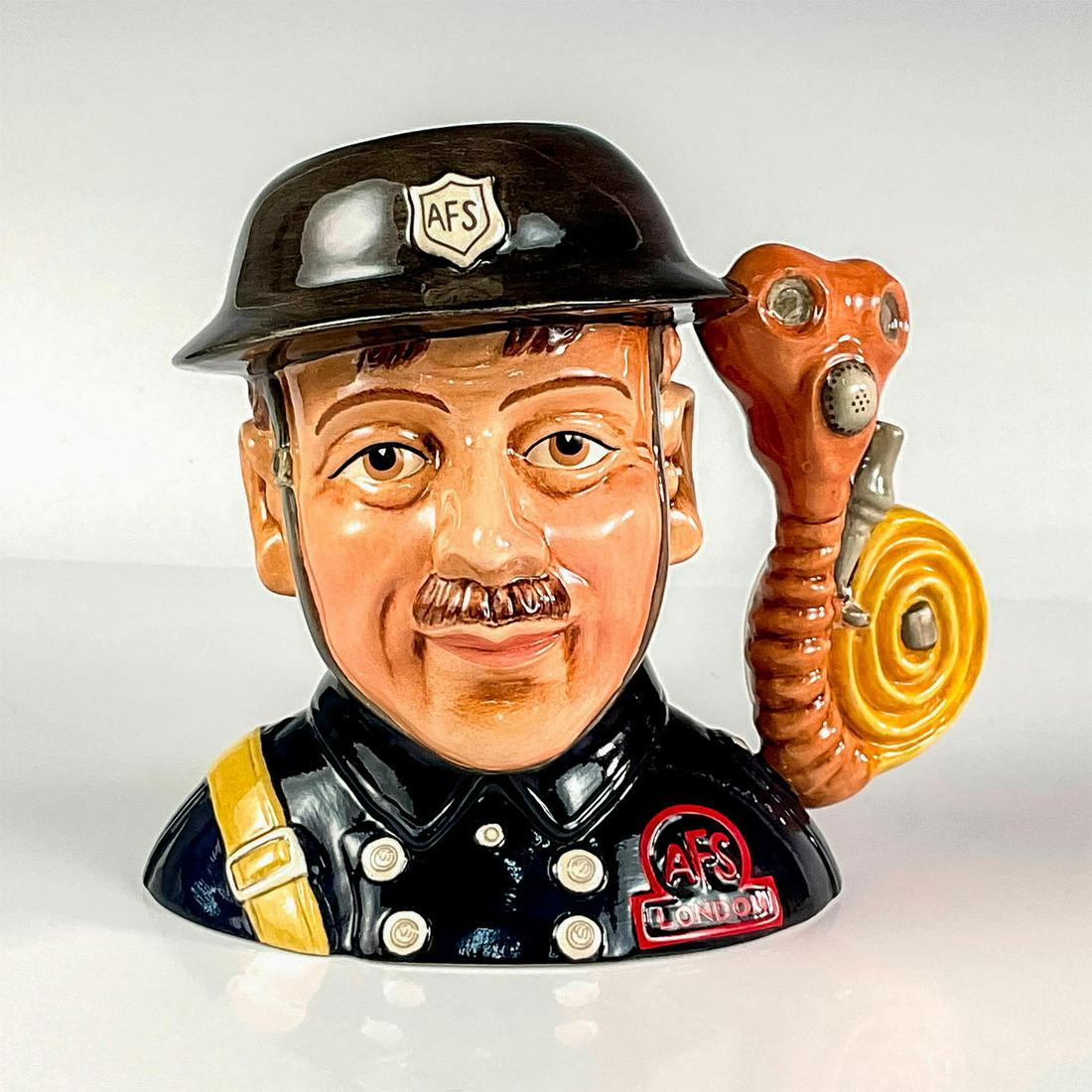 Fireman D7215 - Medium - Royal Doulton Character Jug: Style Three, gas mask and water hose handle. Navy, tan, brown, and red. The third version of the Fireman is part of the Nostalgia series and was the complimentary gift to 2007 RDICC duespayers.Series: