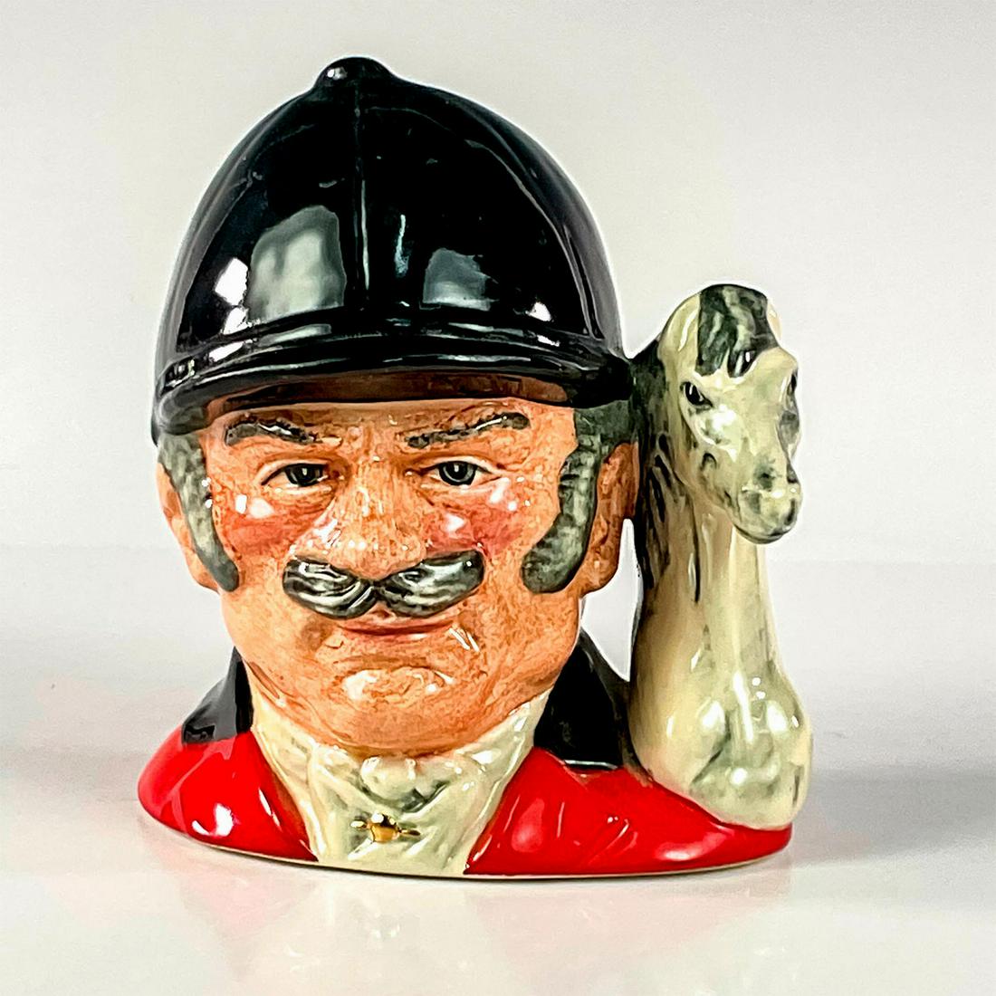 Master Equestrian D6898 - Small - Royal Doulton Character Jug: Dark blue, red, and white coloration. This piece was released in the U.K. as The Master, and in North America as the Equestrian.Royal Doulton backstamp. Artist: Stanley J. Taylor Issued: 1991 - 1995 D