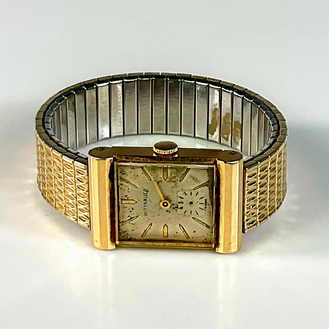 Vintage Wittnauer Unisex 14K Gold Case Stretch Band Watch: Gold tone markers, gold tone hands, 14k case and bracelet. Speidel pat. 2.689.450 on inside of each link. 14k gold on back of case. Face measures: 1.25in H x 1in L x 0.25in W. Band: 5.50in L unstretch