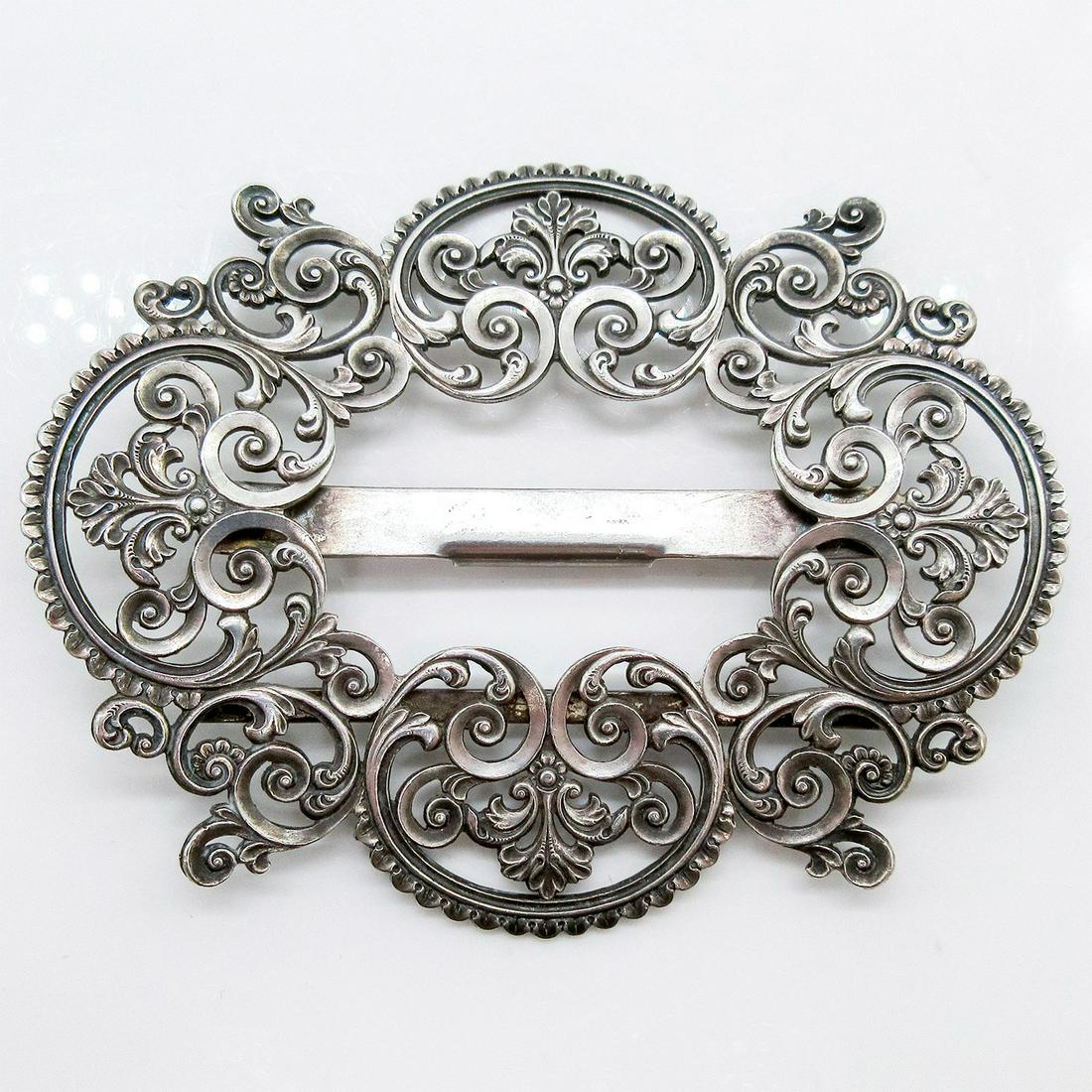 Sterling Silver Ornate Belt Buckle: Sterling carved buckle in an intricate swirls and leave design. 'Sterling' impressed stamp on the back. Weight: 38g Issued: 20th c. Dimensions: 3"W x 3.5"H
