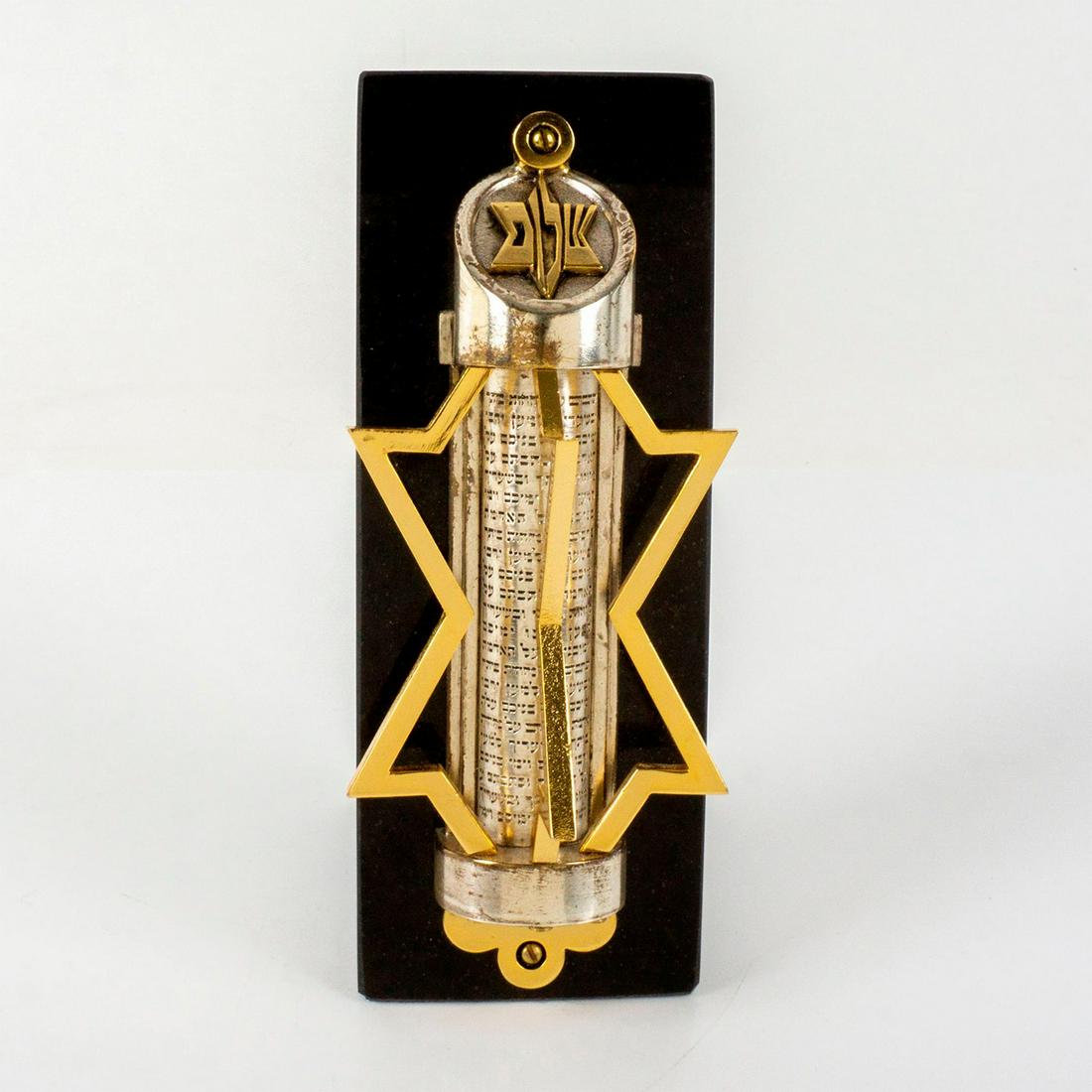 Frank Meisler (Israeli, 1925-2018) Magen David Mezuzah: The gilded Star of David is moveable from side to side. The core of the design is the inscription in metal of the Hebrew words: â€˜ And you shall write them on the doorposts of your ho