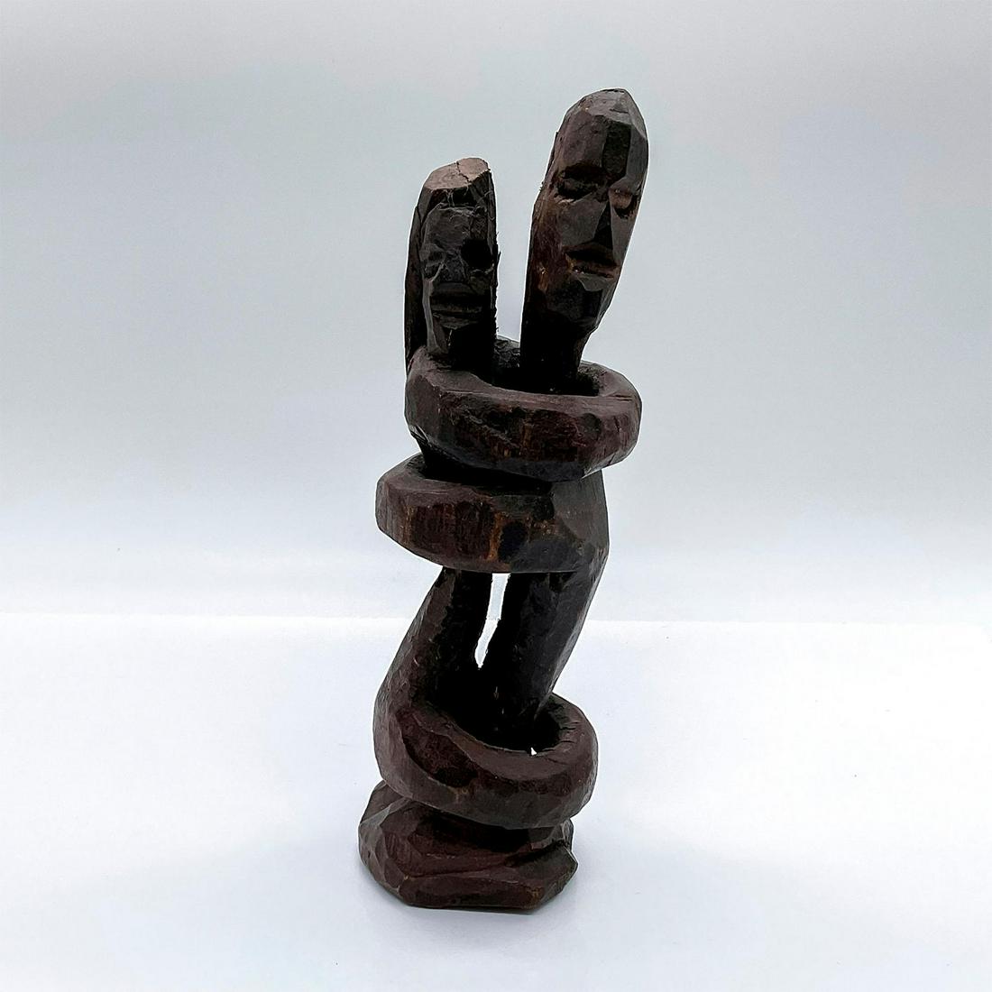 African Hand Carved Couple Figural Sculpture: A figure of a man and a in woman in an embrace. Figure crafted from a single piece of lumber. Dimensions: 3.5"L x 3"W x 9"H Country of Origin: Africa