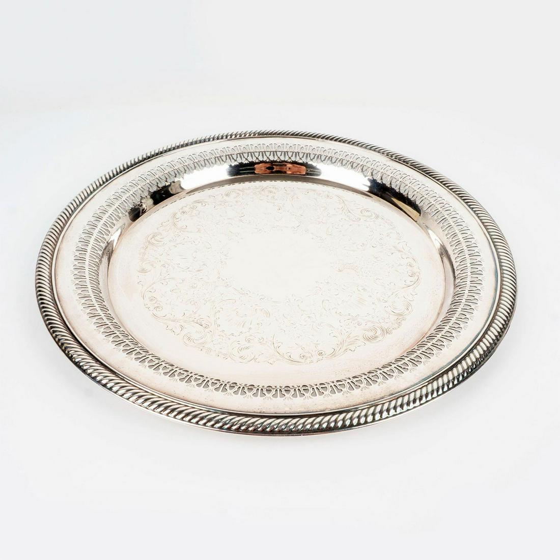 International Silver Co. Filigree Charger Plate: An impressive Rococo- style silver plate with piercing and fluting borders. International Silver Co. engraved marking. Dimensions: 1"H x 12.5"Dia. Manufacturer: International Silver Co.