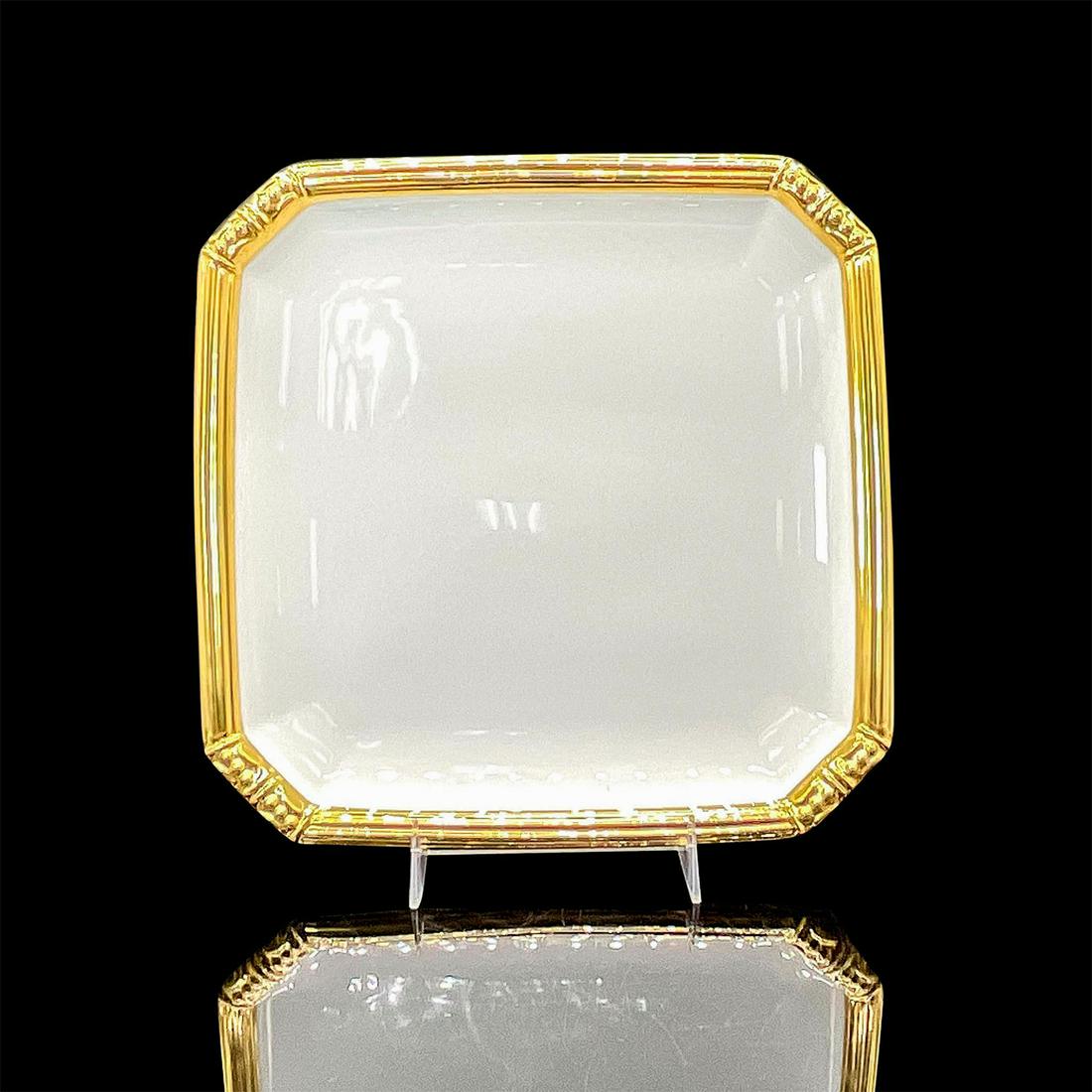 Katy Briscoe White Bone China Plate, Bangles: Glazed bone china with hand-painted gold 'Bangles' design rim. Katy Briscoe backstamp. This item has its original box. Issued: 20th c. Dimensions: 8.25"L x 8.25"W Manufacturer: Katy Briscoe Co