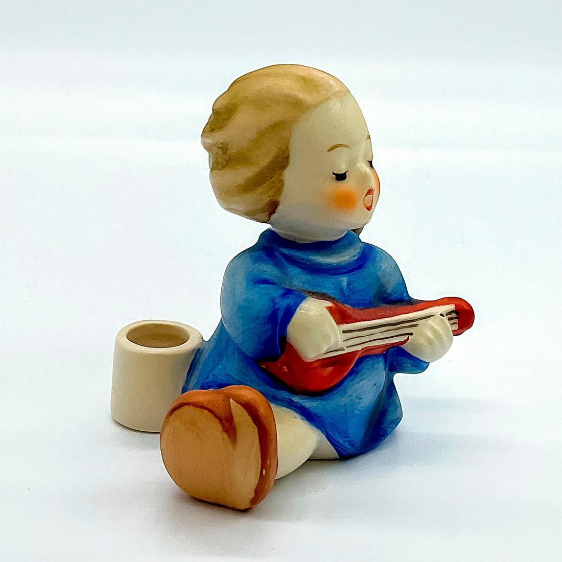 Goebel Hummel Candleholder Figurine, Angel With Lute: Porcelain hand painted in matte finish. Goebel backstamp. Artist: M. I. Hummel Issued: 20th c. Dimensions: 2"L x 1.5"W x 2.5"H Manufacturer: Goebel Hummel Country of Origin: Germany