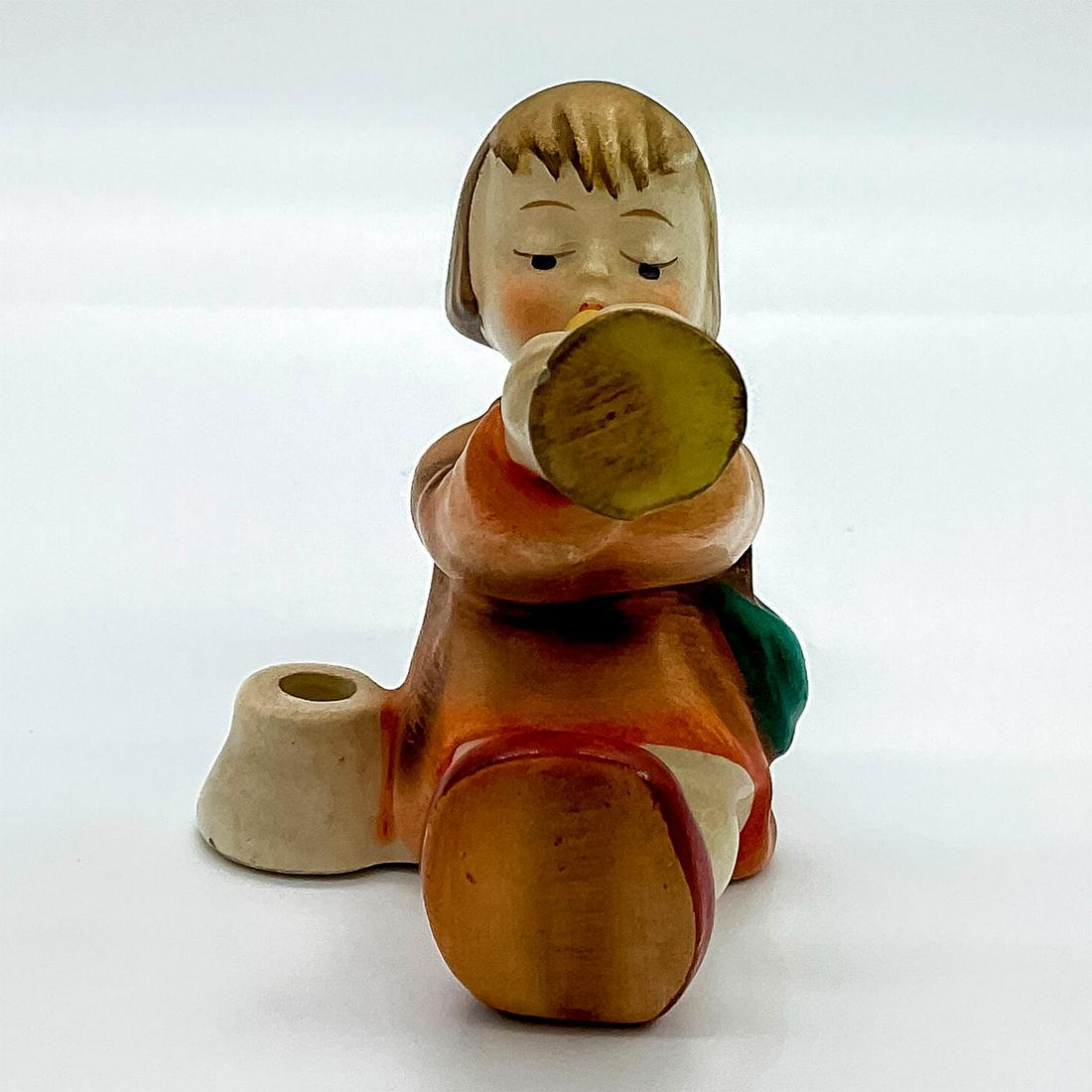Goebel Hummel Candleholder Figurine, Angel With Trumpet: Porcelain hand painted in matte finish. Goebel backstamp. Artist: M. I. Hummel Issued: 20th c. Dimensions: 2"L x 1.75"W x 2.75"H Manufacturer: Goebel Hummel Country of Origin: Germany