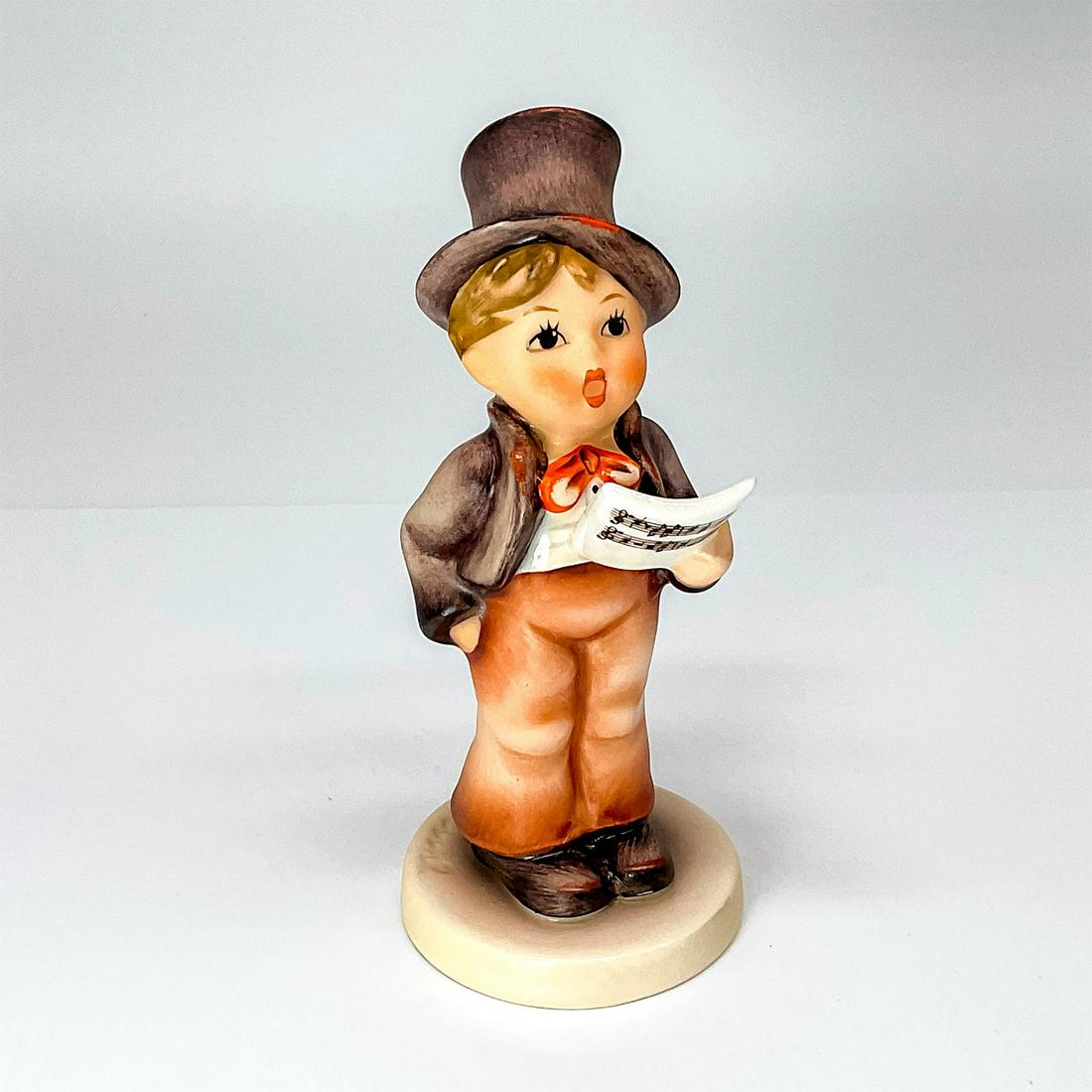 Goebel Hummel Figurine, Street Singer: Adorable little boy in a suit and top hat singing from a music sheet. Goebel backstamp. Artist: M.I. Hummel Dimensions: 2"W x 5"H Manufacturer: Goebel Hummel Country of Origin: Germany