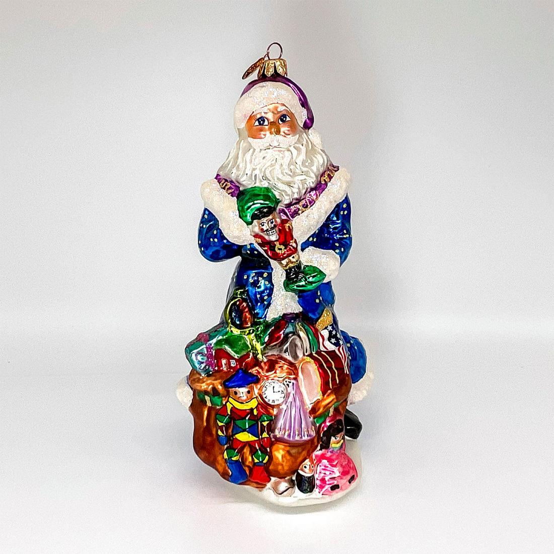 This One's For You - Christopher Radko Christmas Ornament: Colorful, mouth blown, and handcrafted glass ornament depicting Santa with his sack of toys choosing a gift. Gold ornament attached atop piece. Dimensions: 5"L x 4.5"W x 9"H Manufacturer: Christopher 