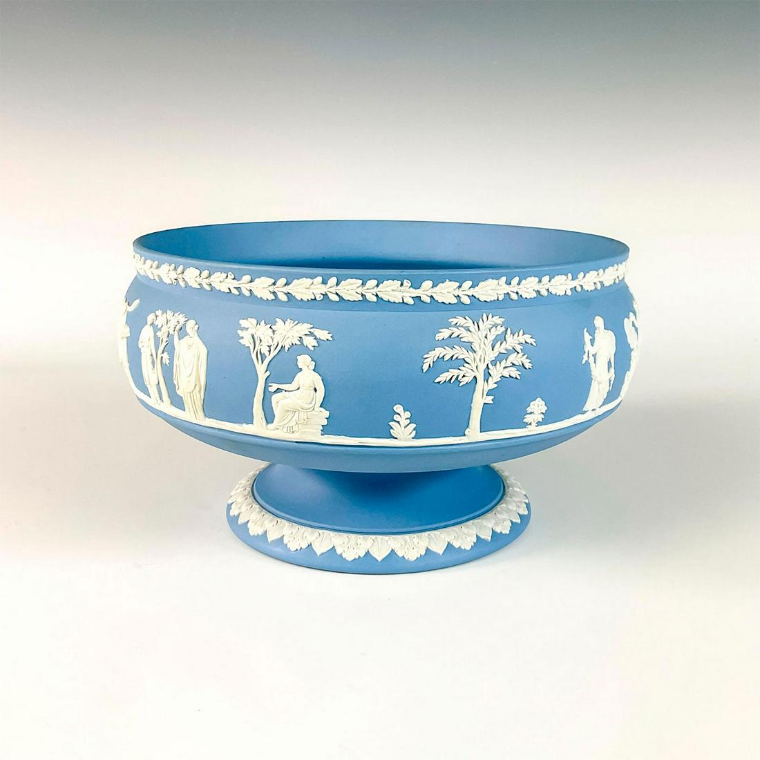 Wedgwood Light Blue Jasper Footed Large Bowl: Elegant raised continual scene of classical ladies in a garden. Rim and foot of bowl adorned with a band of decorative borders. Issued: Early 1900â€™s Dimensions: 4.5"H x 8.5"Dia. Manufacturer: W