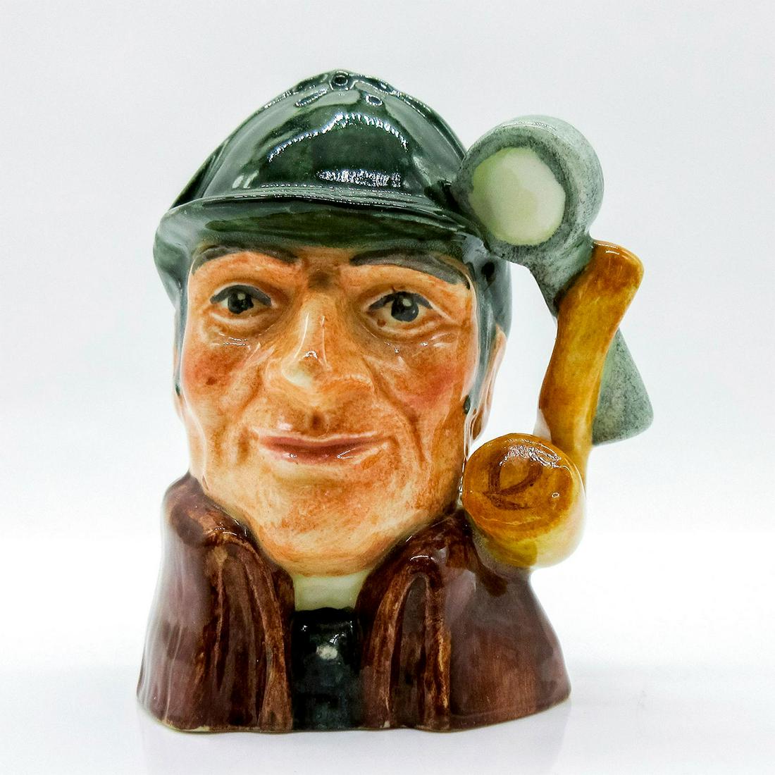 Sleuth D6639 - Mini - Royal Doulton Character Jug: Variation One, dark green deerstalker hat; brown cloak. Arthur Conan Doyle (1859 - 1930), an unsuccessful doctor, published the first of his widely popular detective stories in 1887. The amateur sleut