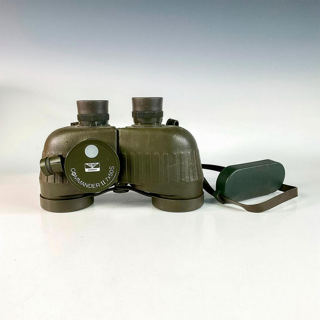 Steiner Military-Grade Binoculars Commander II 7X50S: Olive green housing. Range finding reticle on right side. Rubber eye cups. Compass light is untested. Issued: 20th c. Dimensions: 8.25"L x 5.75"W x 4.25"H Manufacturer: Steiner Country of Origin: Germ